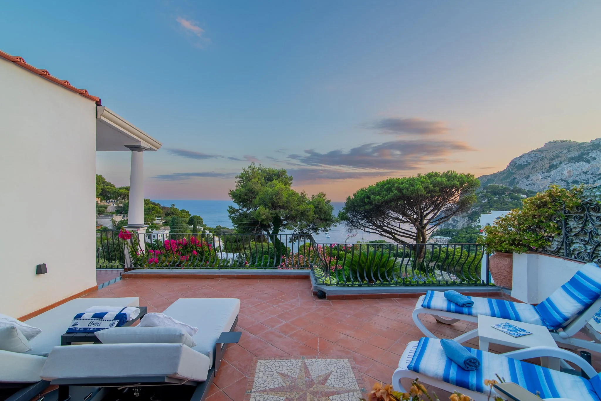 Dramatic sunset skyline over the ocean from a luxury private penthouse in Capri Italy.