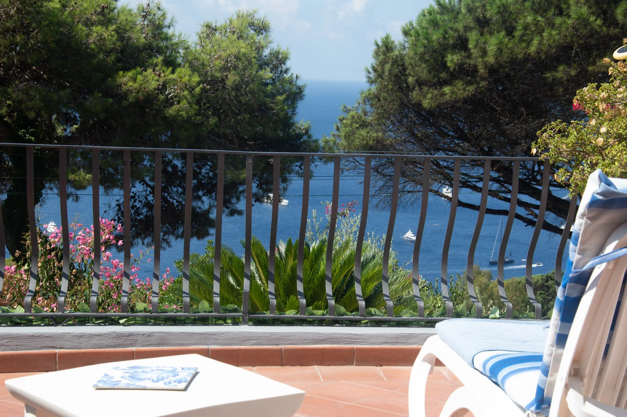Relaxing sea view next to a white sun lounger and tile coffee table.