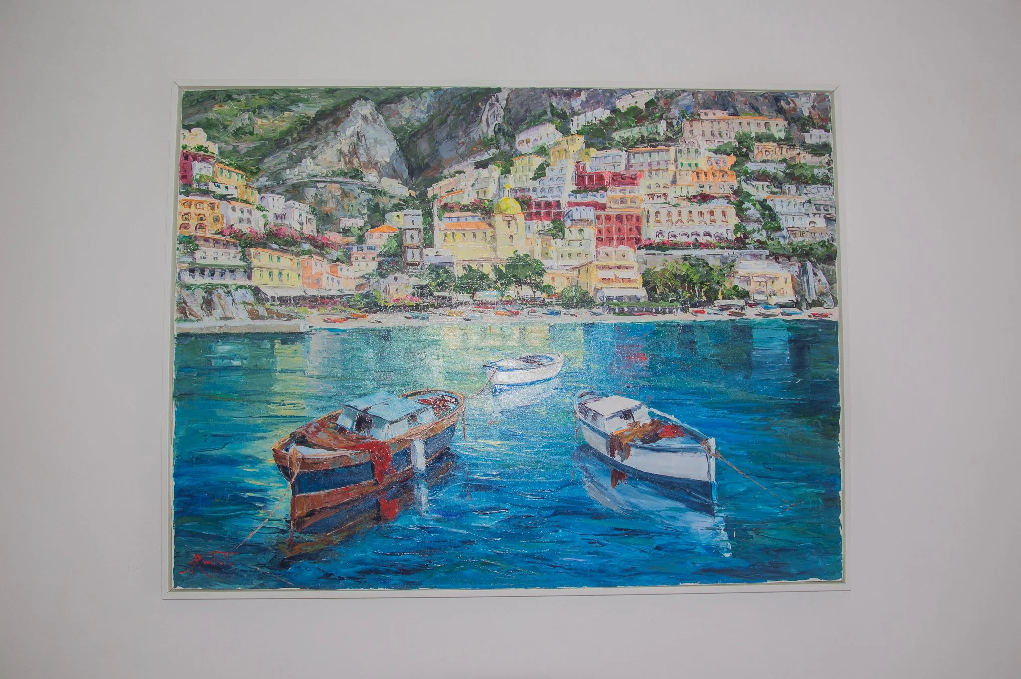 Vibrant oil painting depicting traditional boats and colorful houses of Positano on a white wall.