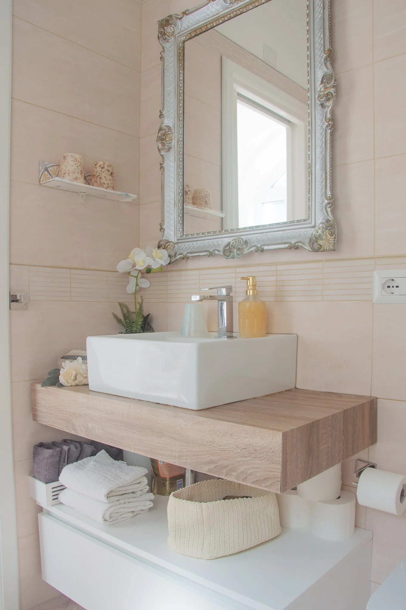 Modern bathroom vanity with a square ceramic sink and ornate silver mirror at a Capri luxury rental.