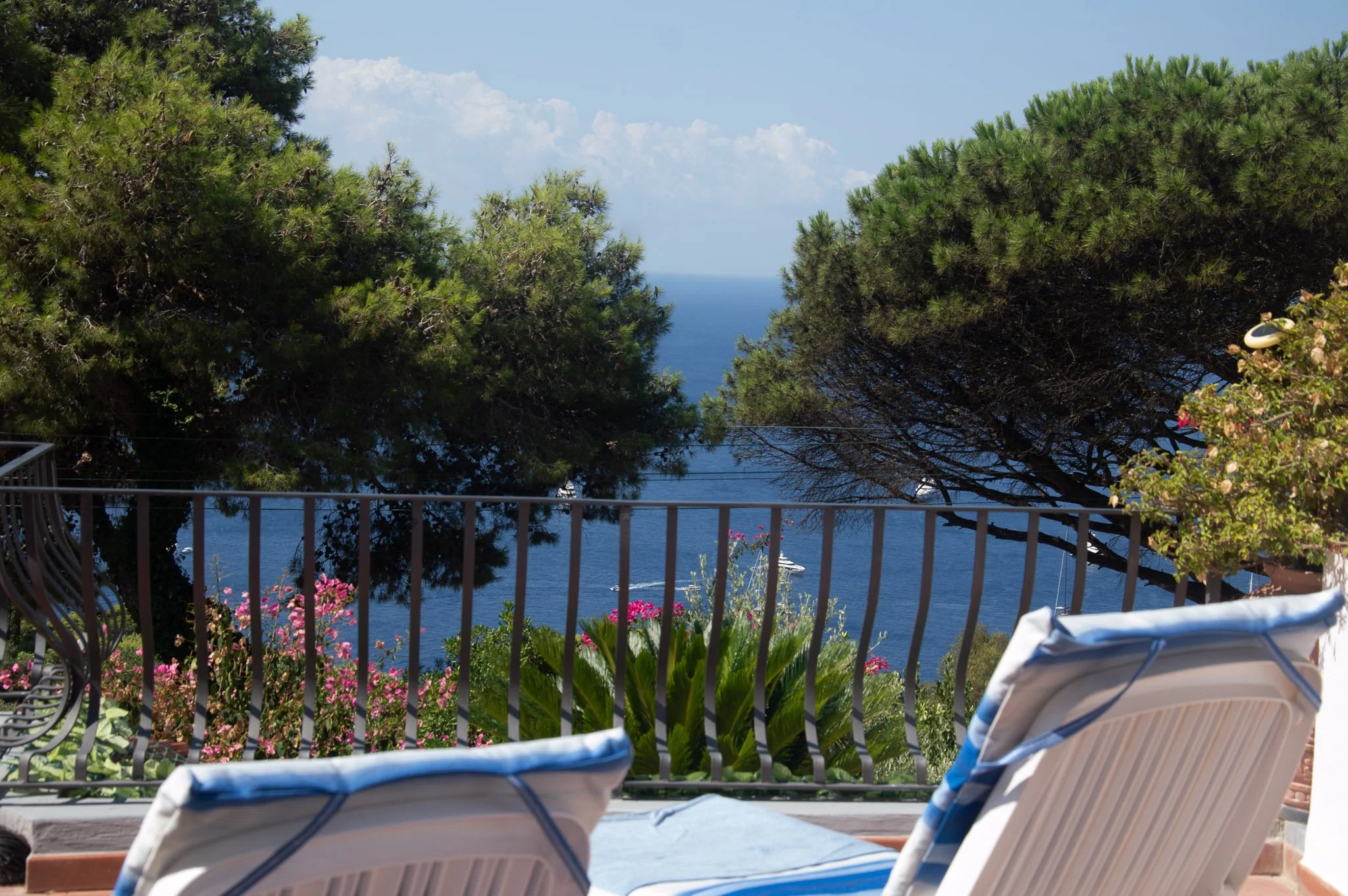 Sunbathing deck at a private holiday home in Capri Italy with comfortable blue loungers facing the water.