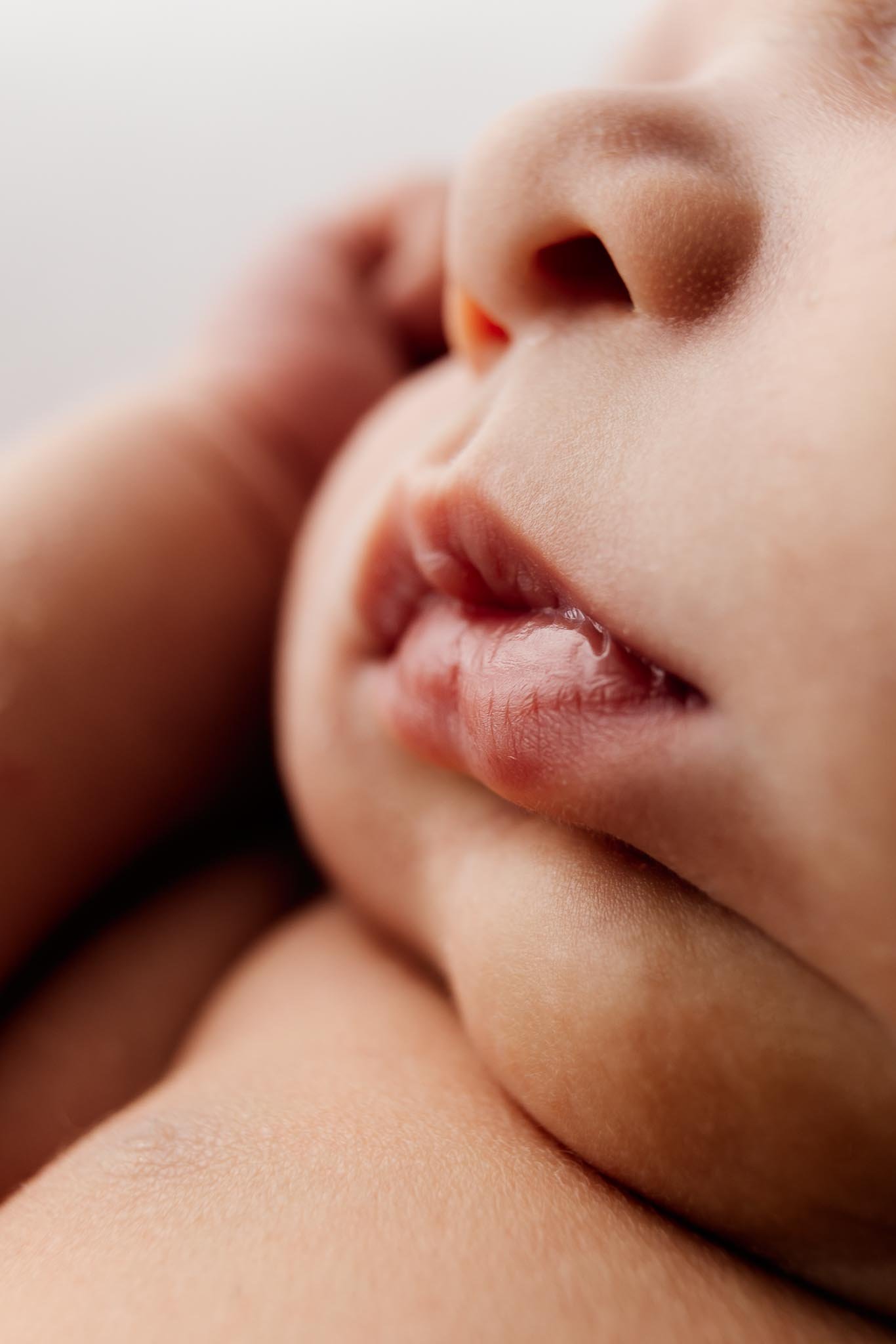 Close-up of a person's nose and lips, with skin detail visible, and a soft focus background.