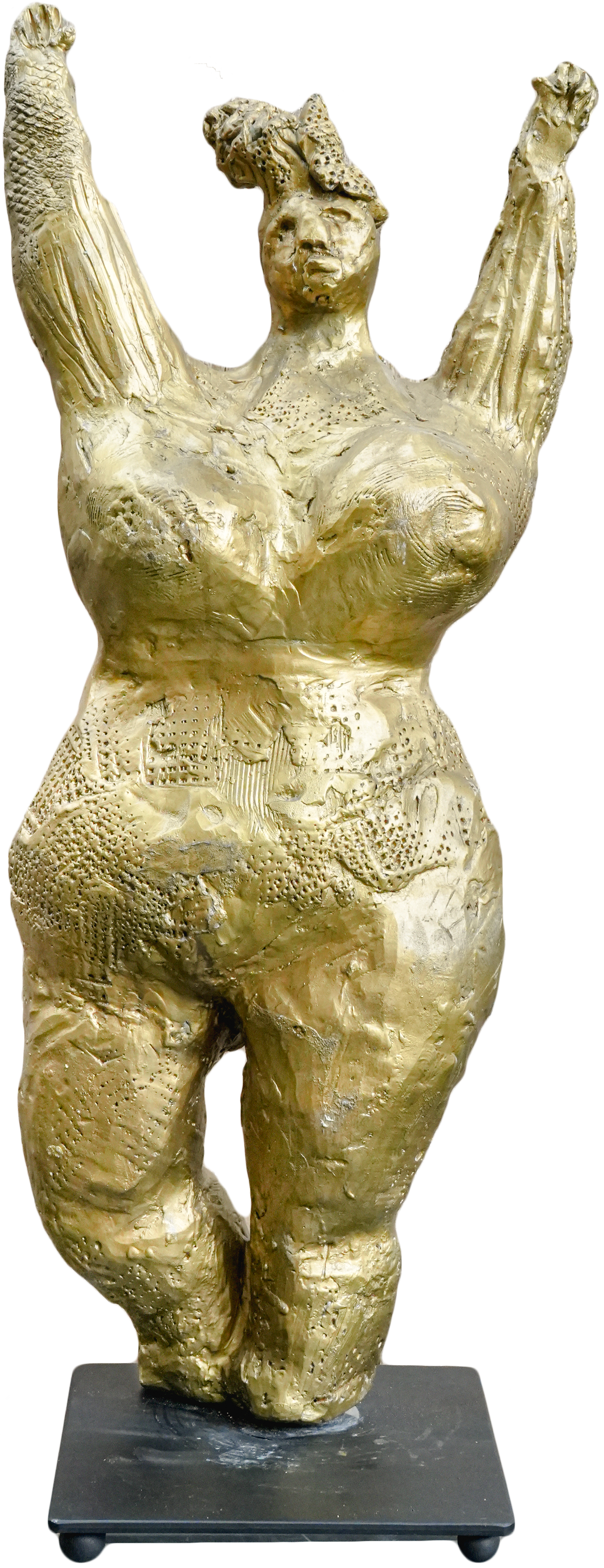 A gold sculpture of a female figure with arms raised, featuring exaggerated and textured facial and body features, mounted on a black base.