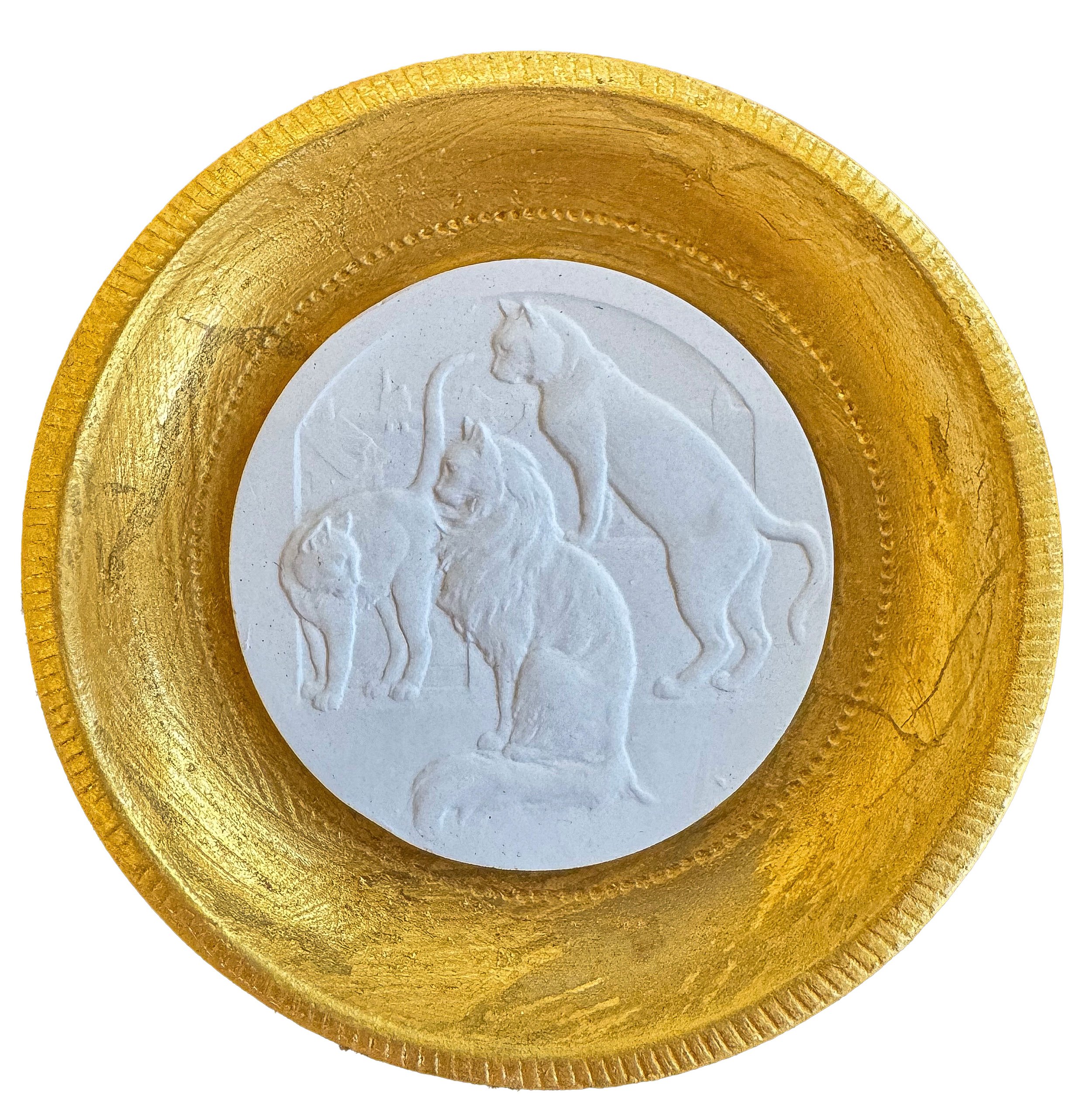 Close-up of a gold-colored round medallion with a white relief of two horses in the center.