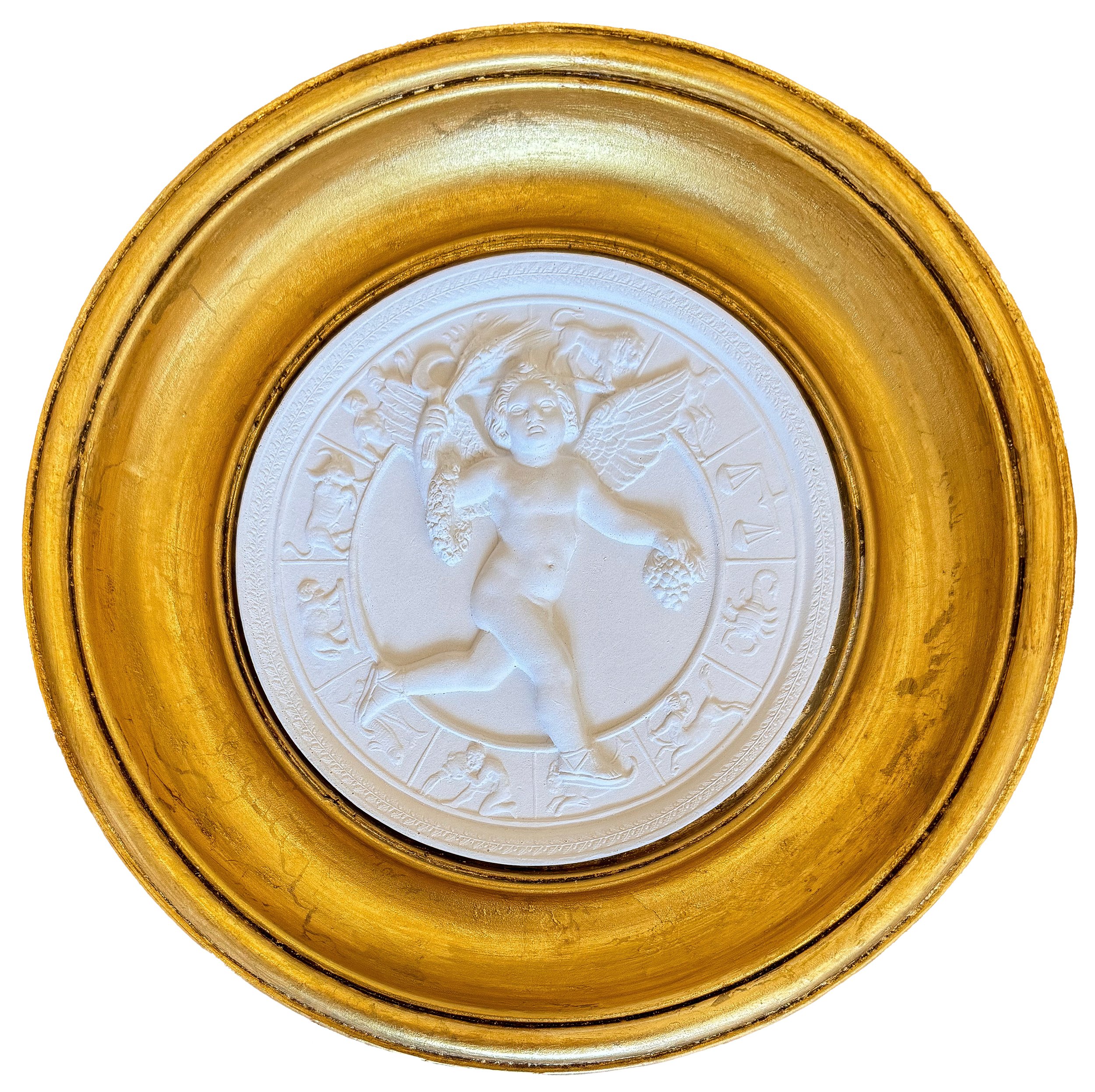Close-up of a gold ornate frame surrounding a white embossed medal with a face and angels.