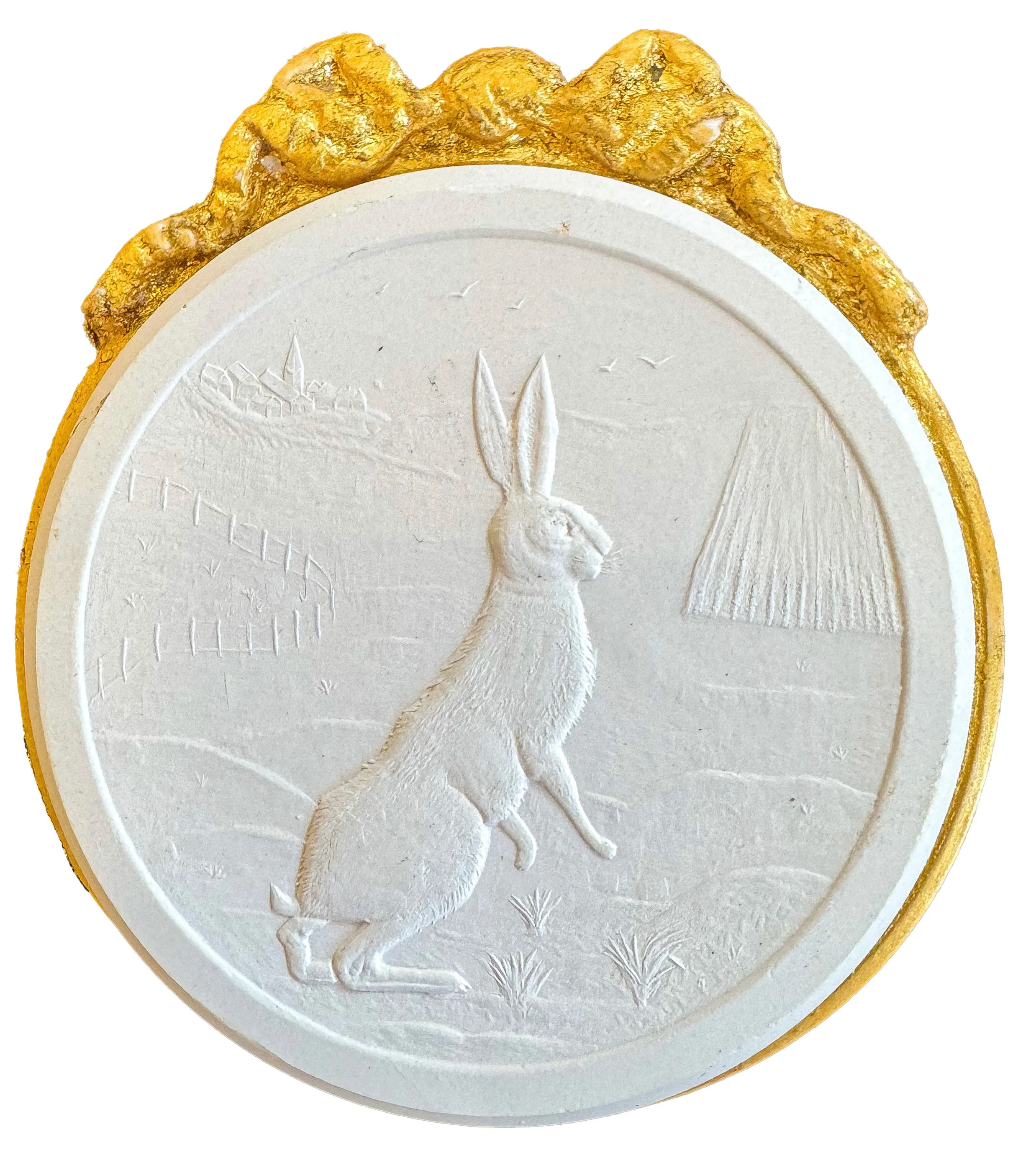 Close-up of a white egg with a gold decorative border and an embossed rabbit silhouette on the yolk side.