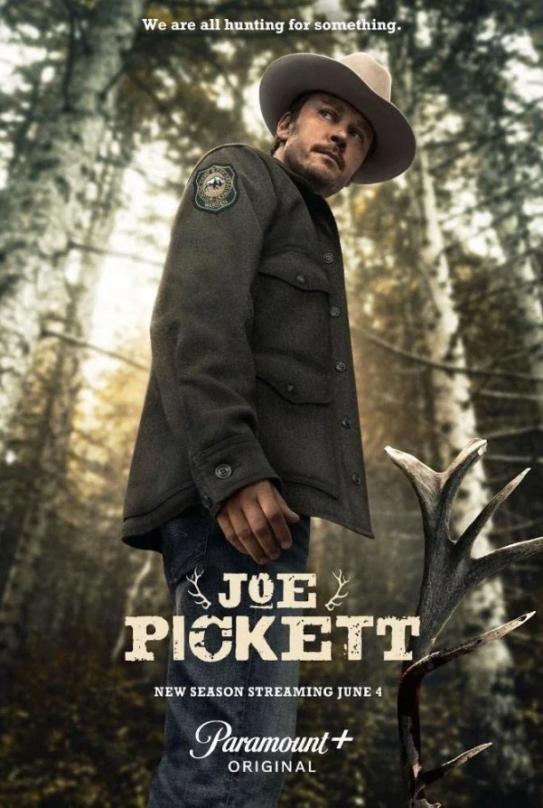 A man in a sheriff's uniform with a large hat stands outdoors in a forested area, with a deer antler visible in the foreground. The text says, "We are all hunting for something." The poster promotes the TV show "Joe Pickett," streaming on Paramount+ starting June 4.