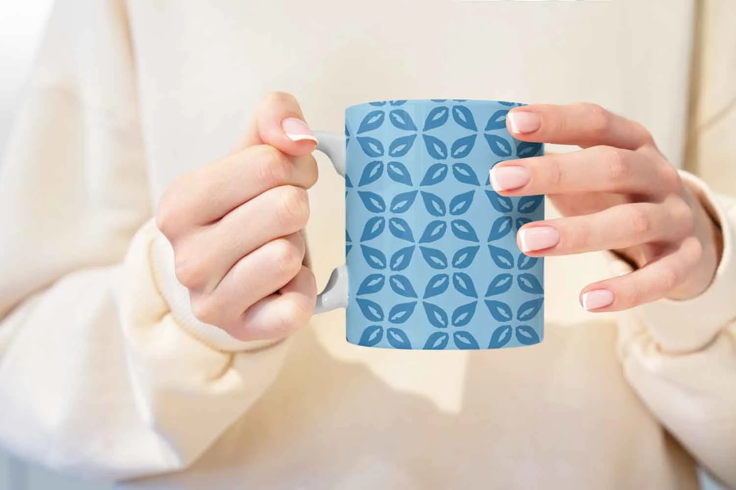 Woman holding a mug with original artwork of blue geometric floral pattern by Studio Victoria Louise.