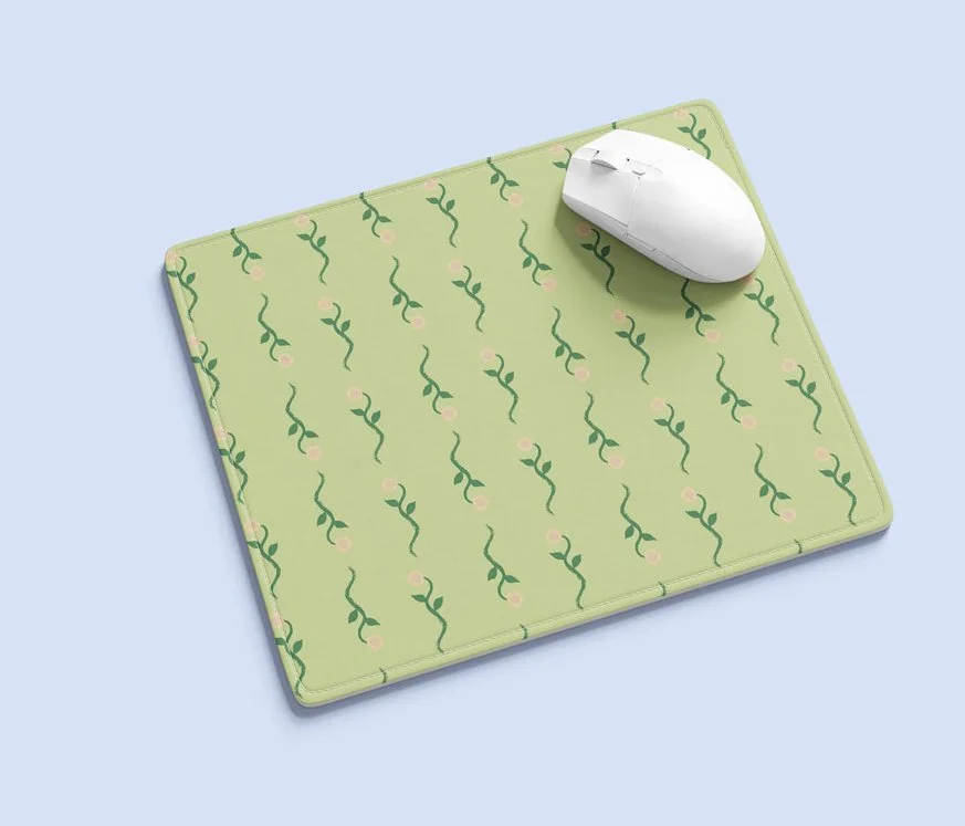 A green floral patterned mousepad with white mouse on top by Studio Victoria Louise.