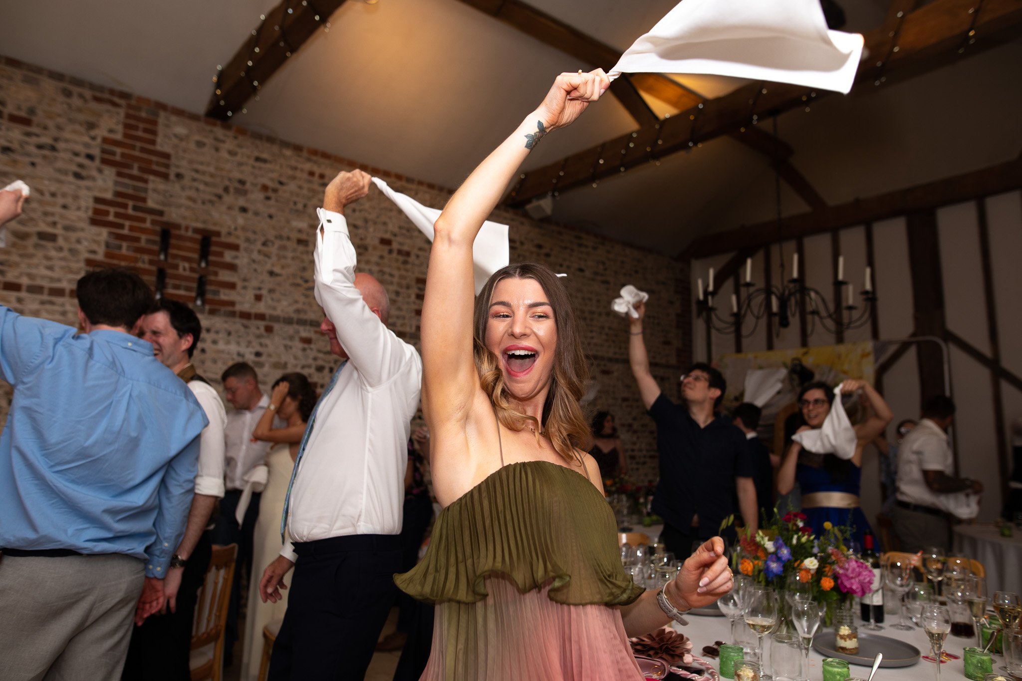 guests wave napkins in the air to announce the arrival of the couple
