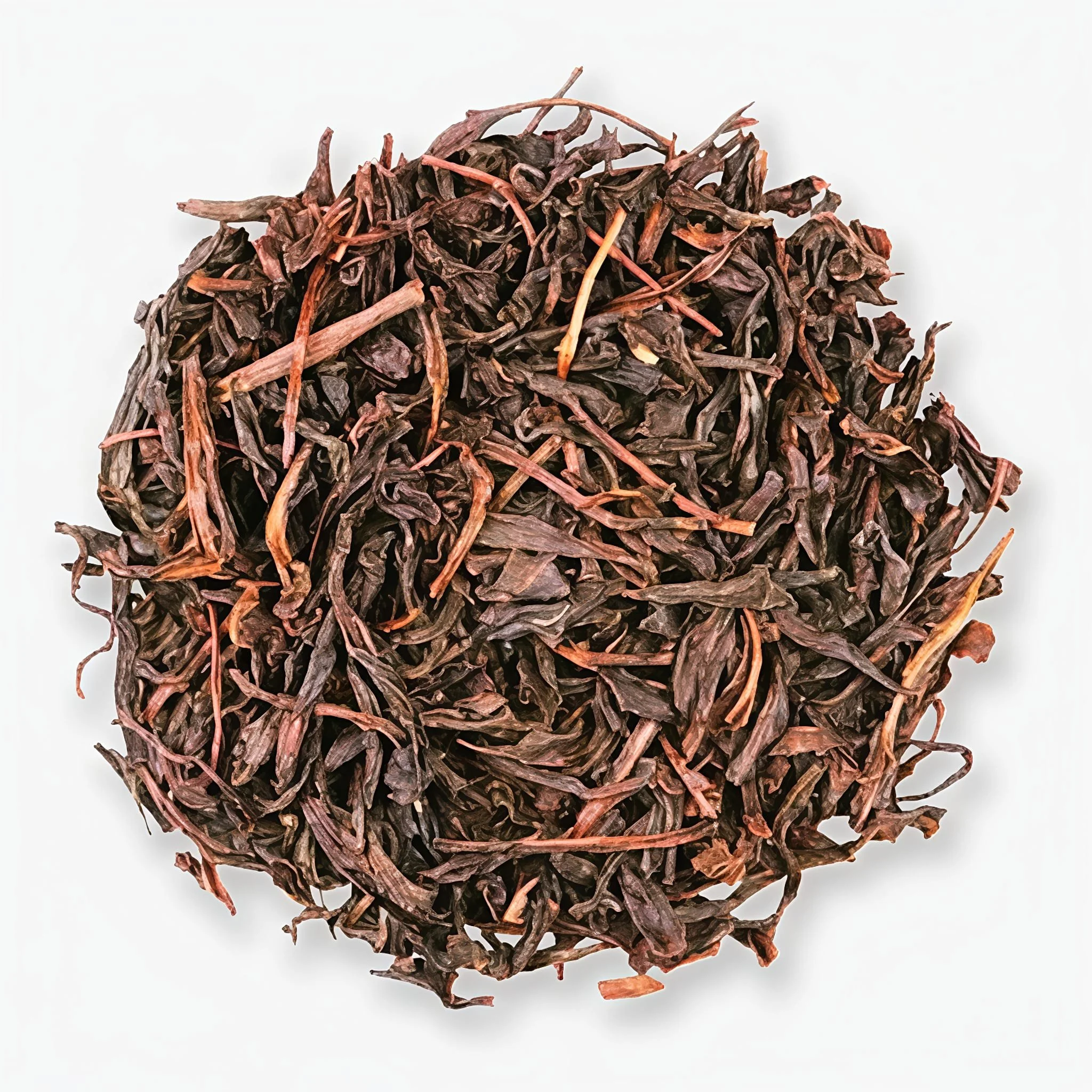 A pile of twisted, dried, dark brown ceylon tea leaves on a white surface.