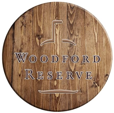 Circular wooden sign with text 'WOODFORD RESERVE' and an outline of a whiskey glass at the top.