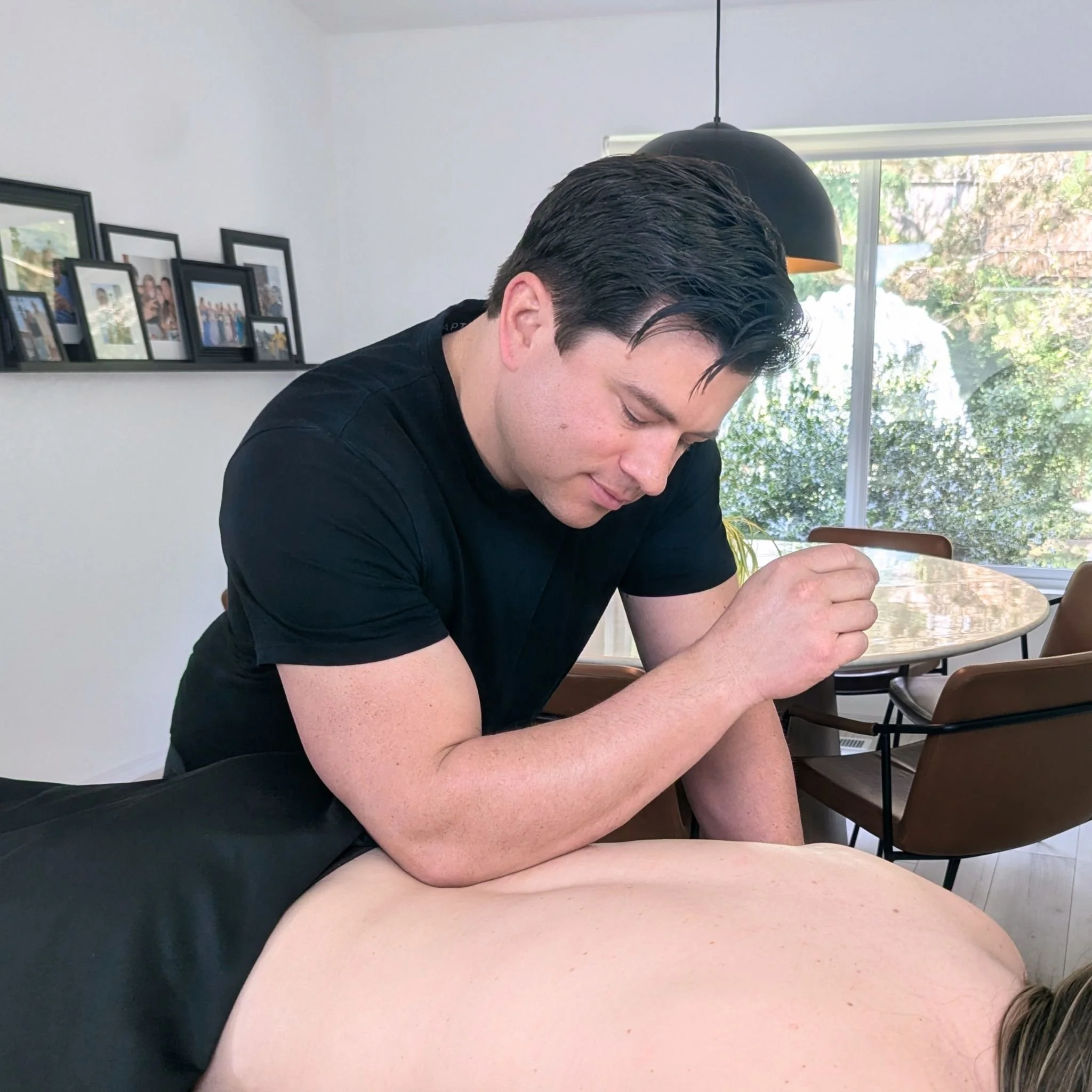 Clinician applying deep tissue elbow pressure to a client's lower back during a Redmond mobile massage.
