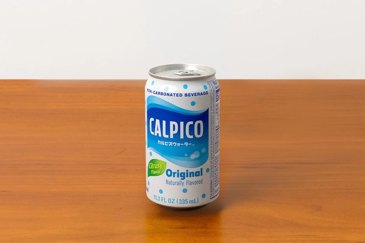 A can of Calpico original flavor non-carbonated beverage on a wooden table.