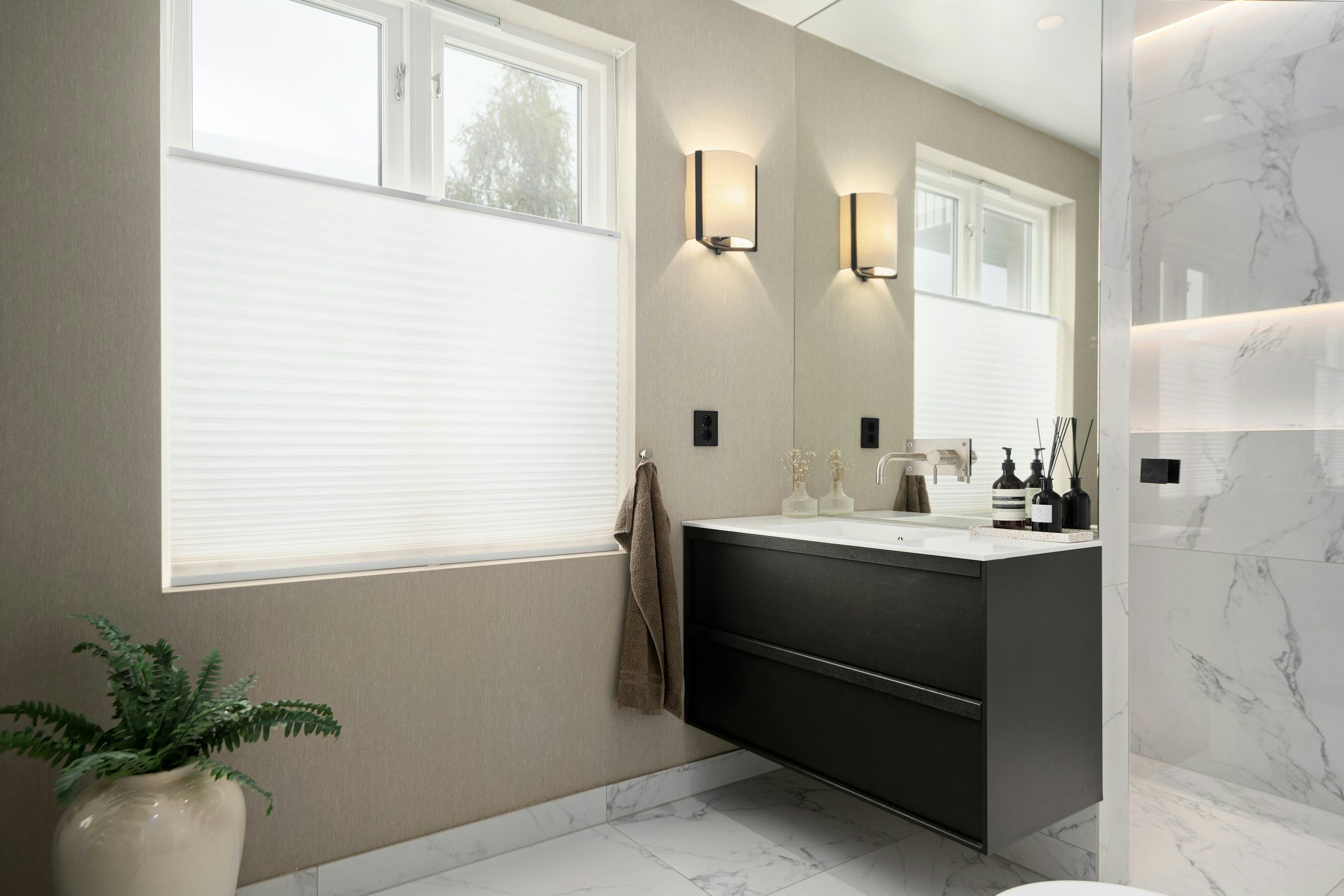 A modern bathroom with a window with Top-Down cellular honeycomb shades.