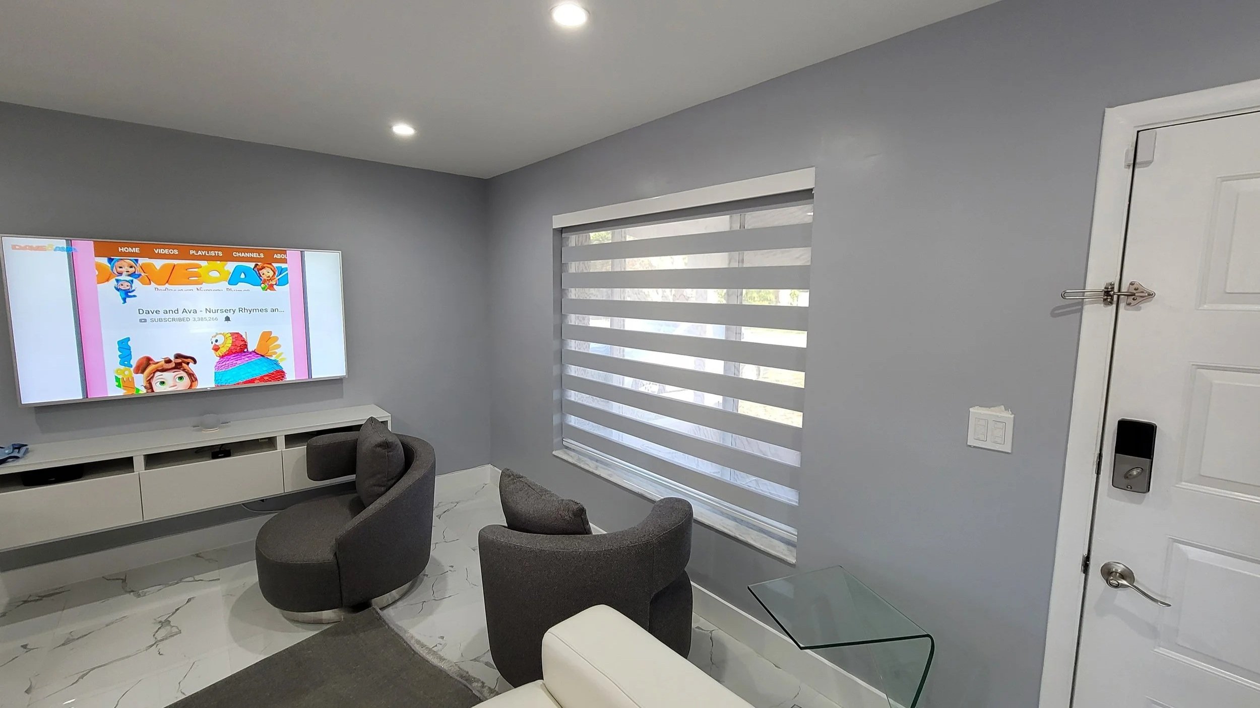 A living room with open dim-out zebra roller shades for room darkening, privacy, and heat rejection.