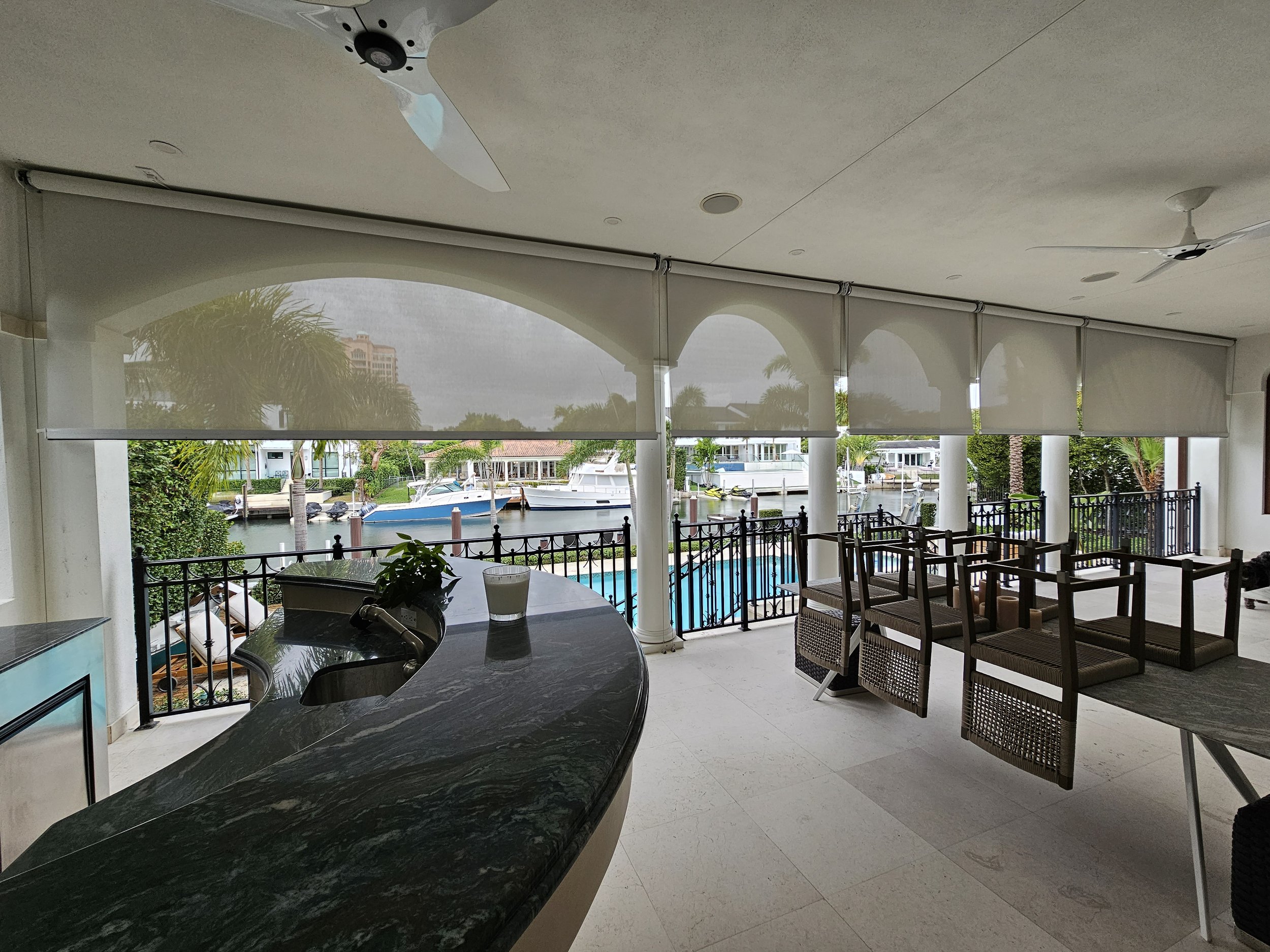 Covered patio with wire guided exterior screens for expanding living space outdoors.