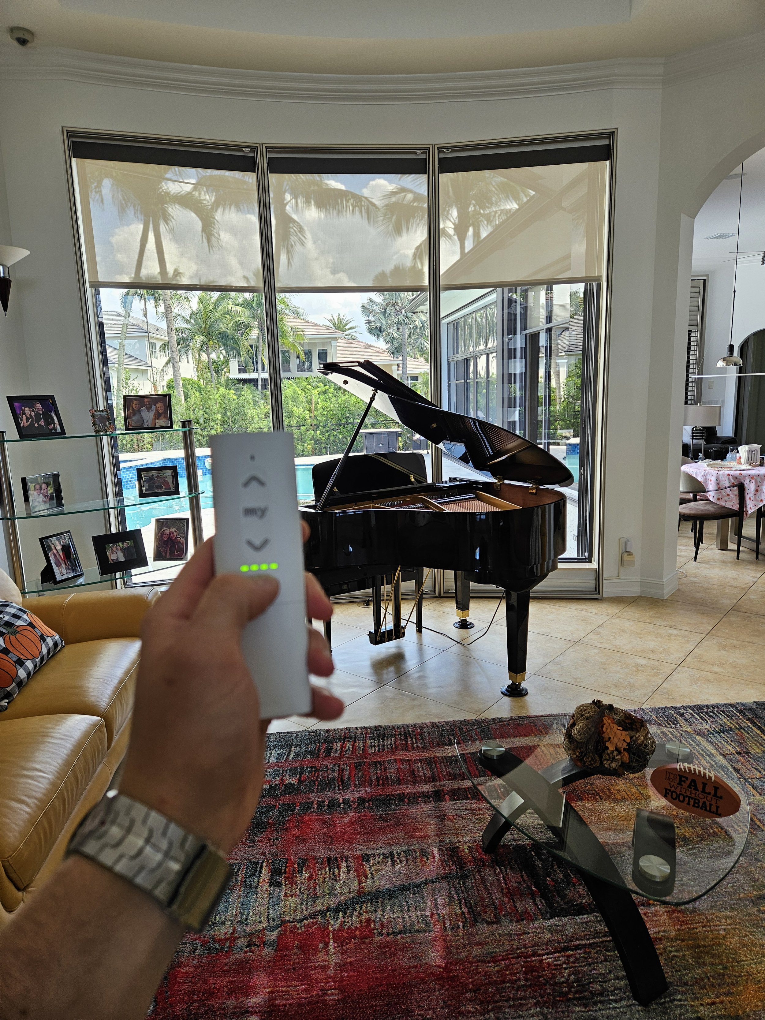 Living room with motorized roller screens using Somfy hard wired low voltage motors for smart home integration.