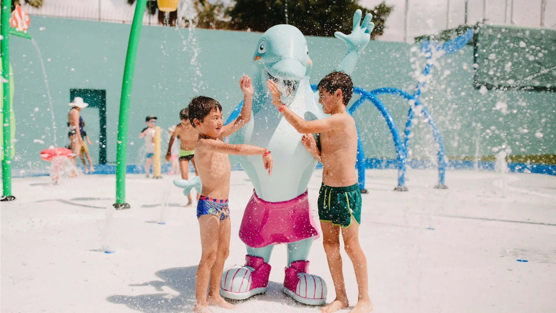 Kinderen spelen met een flamingo-zombie waterattractie in een waterpark.