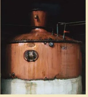 A brown metal industrial tank with a domed top, pipes, and gauges.