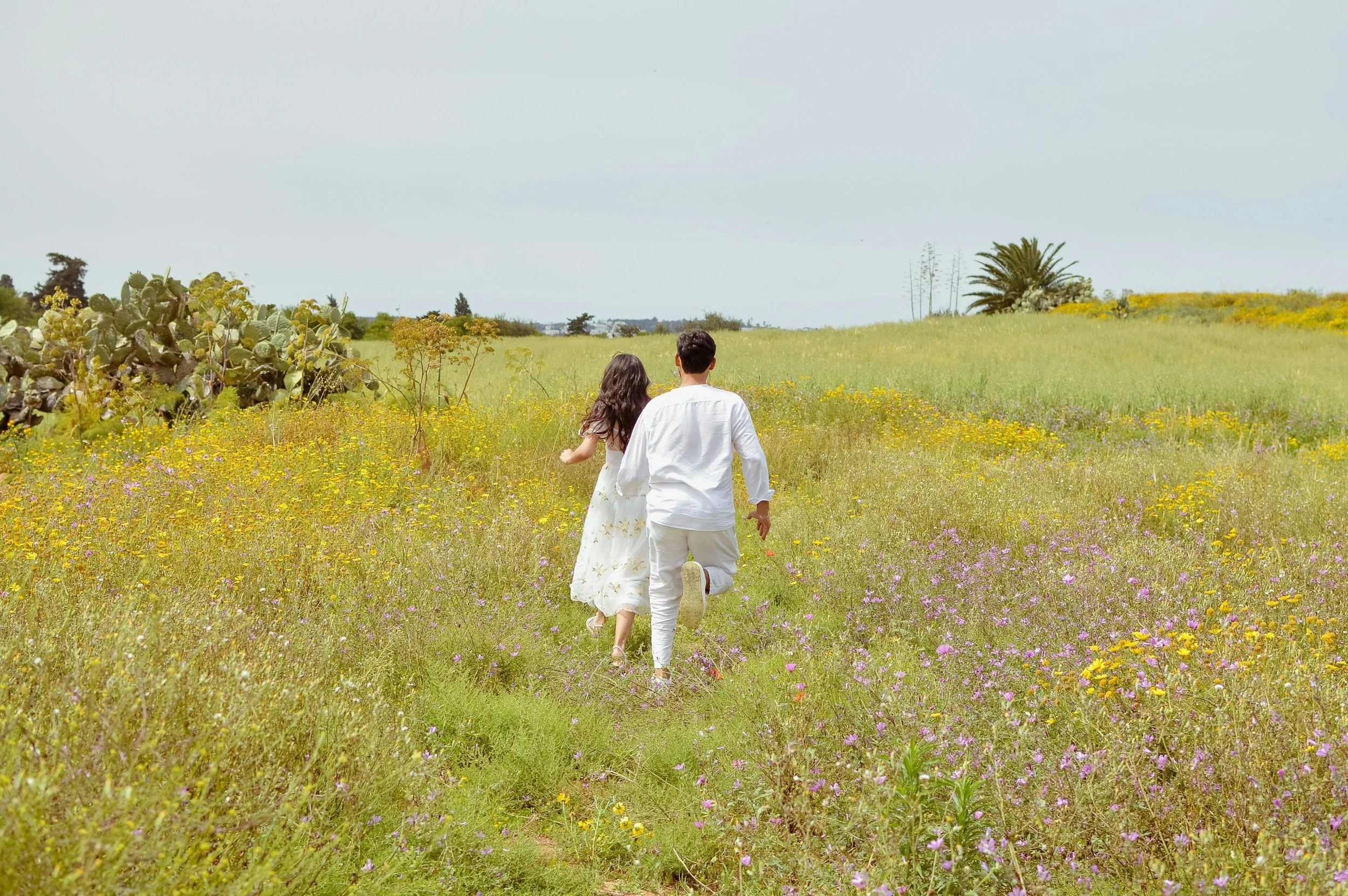 A man and woman walking together through a field of wildflowers, symbolizing hope, growth, and moving forward.