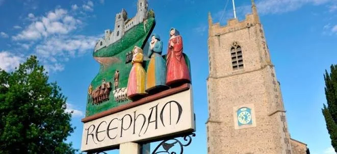 Colorful church sign featuring a castle, figures in vibrant robes, and a clock tower in the background.