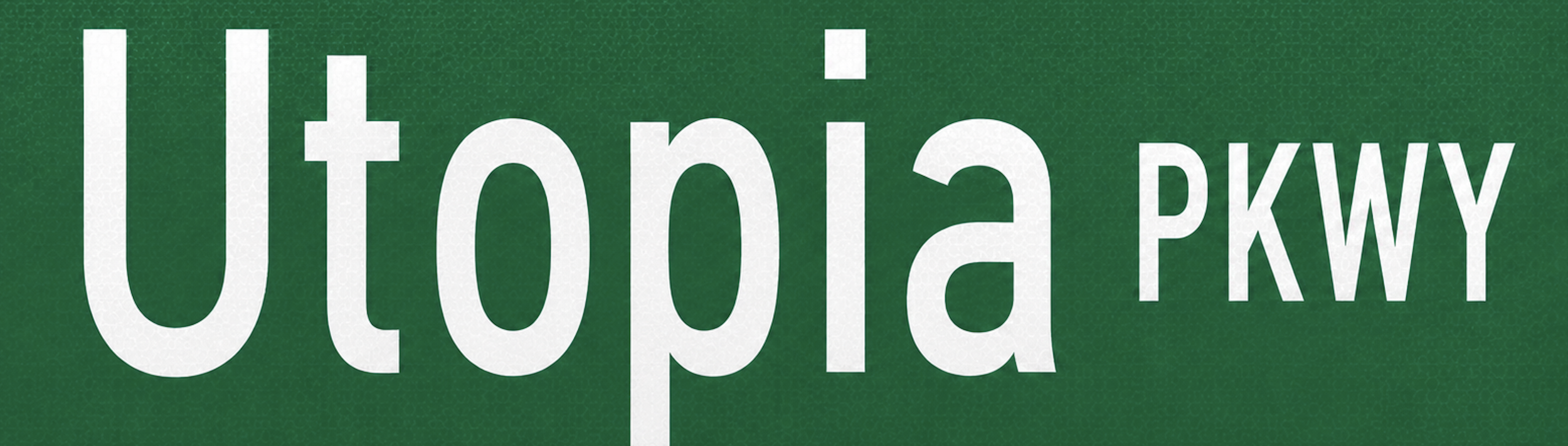 Close-up of a green street sign with white text saying 'Utopia Parkway'