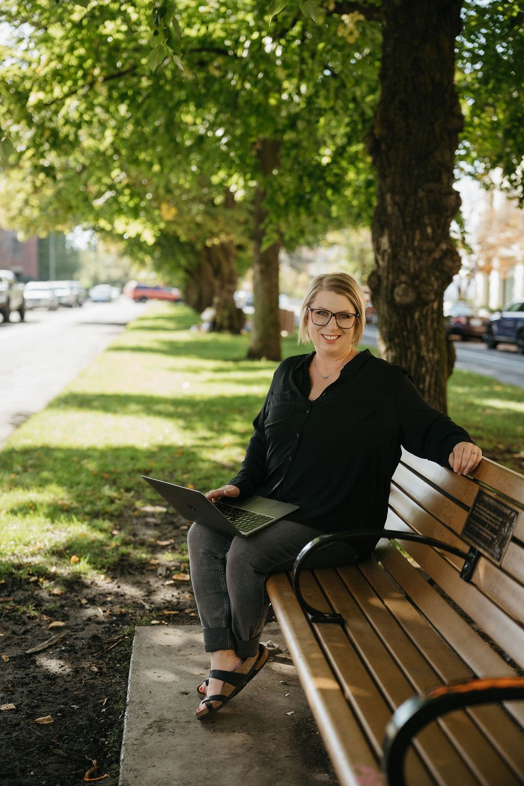 Woman sitting on a bench with a laptop on her lap
