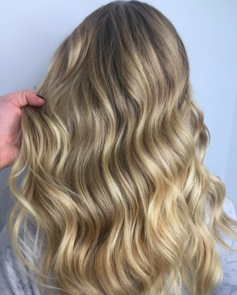 Blonde, wavy hair of a person with light highlights and lowlights. lived in balayage bronde vanilla iced latte hair boston hair by leanne rowe