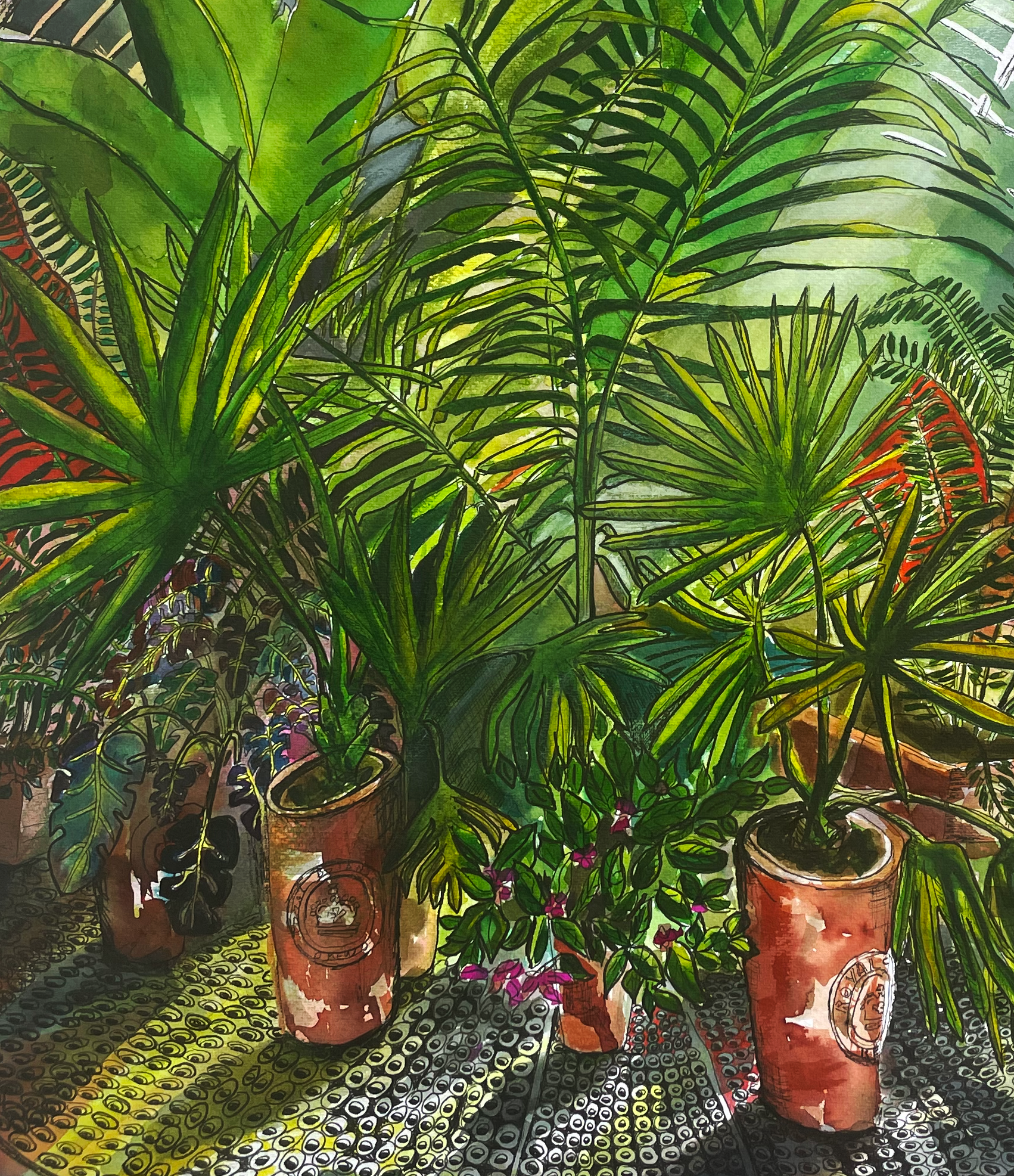 A collection of potted plants including palm-like foliage and flowering plants with pink flowers, set on a colorful patterned surface in a room.