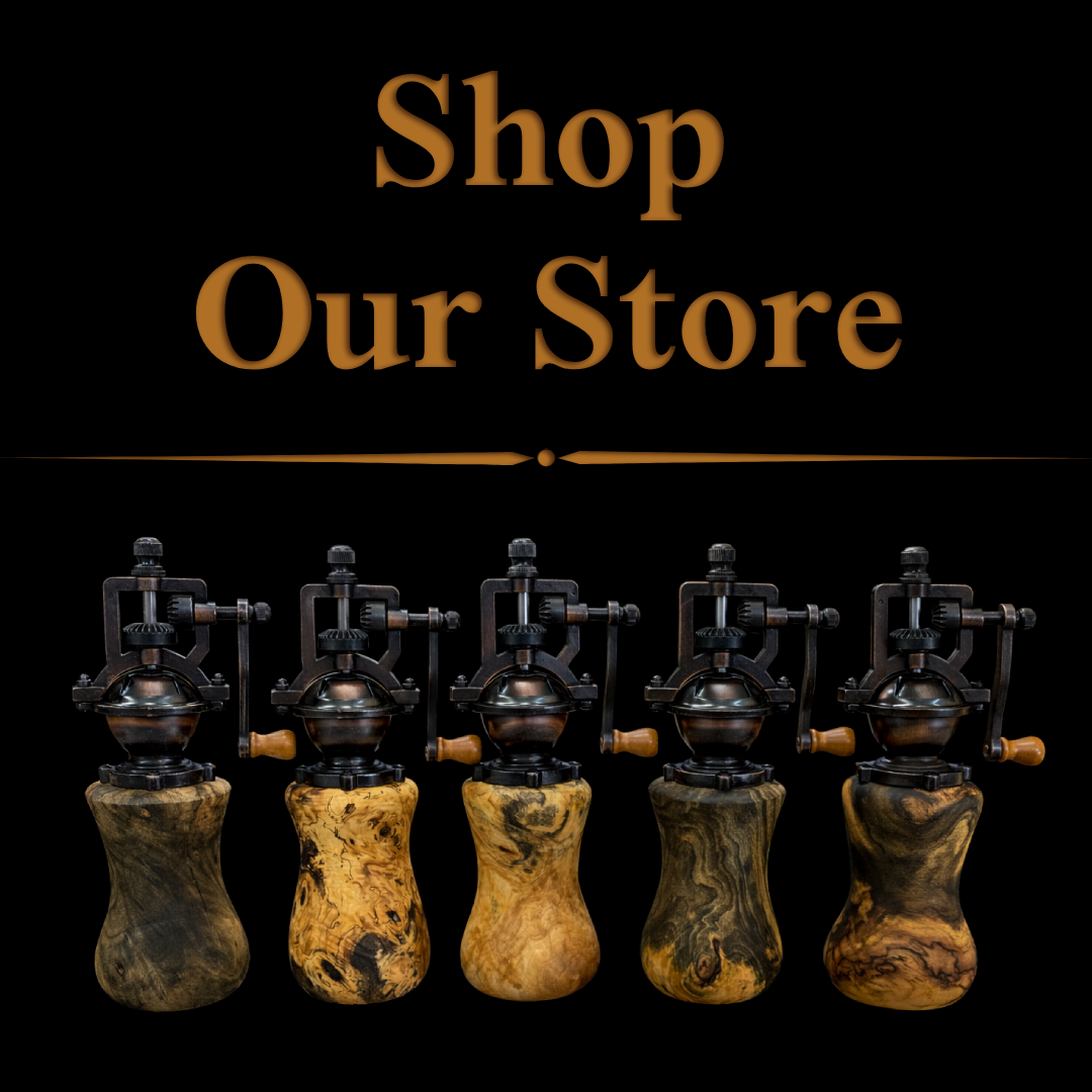 Sign reading 'Shop Our Store' above a row of five vintage coffee roasting machines with wooden handles on a black background.
