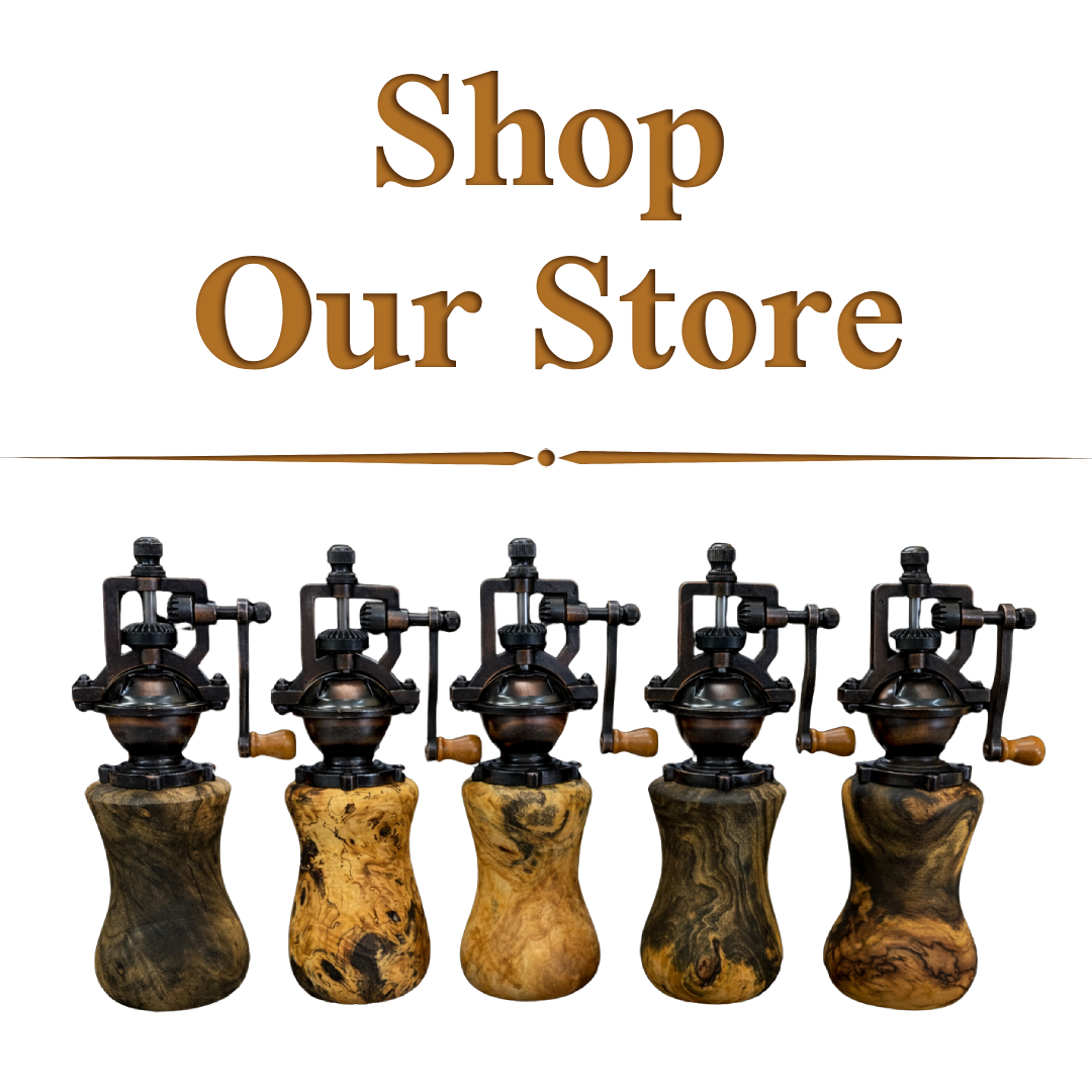 Decorative sign with the text 'Shop our Store' and five antieppermill grinders with wooden handles displayed below.