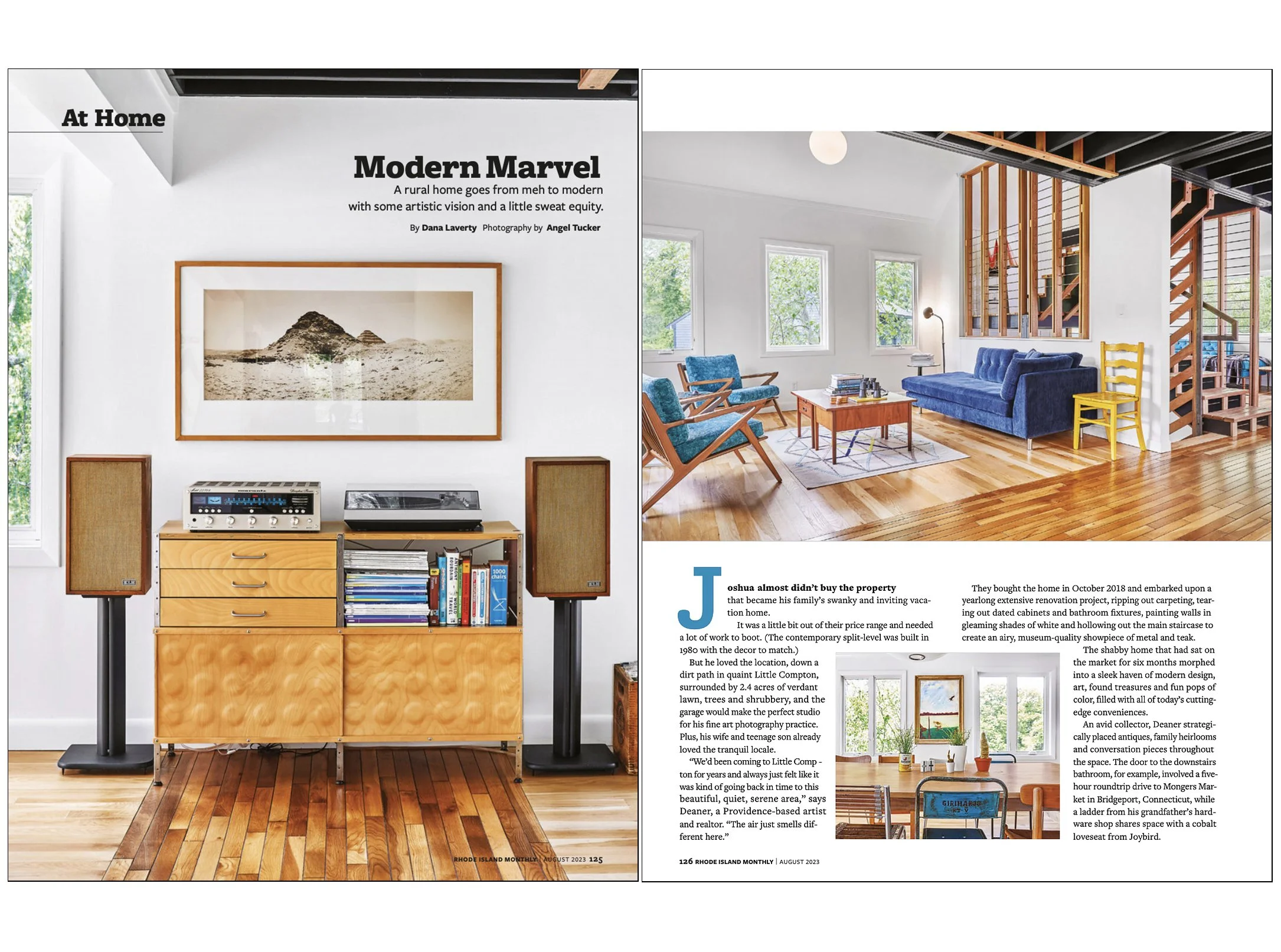 Interior view of a modern living room with large windows, blue velvet sofa, mid-century chairs, wooden coffee table, and a staircase with wooden balusters. Bright and airy atmosphere with natural light.