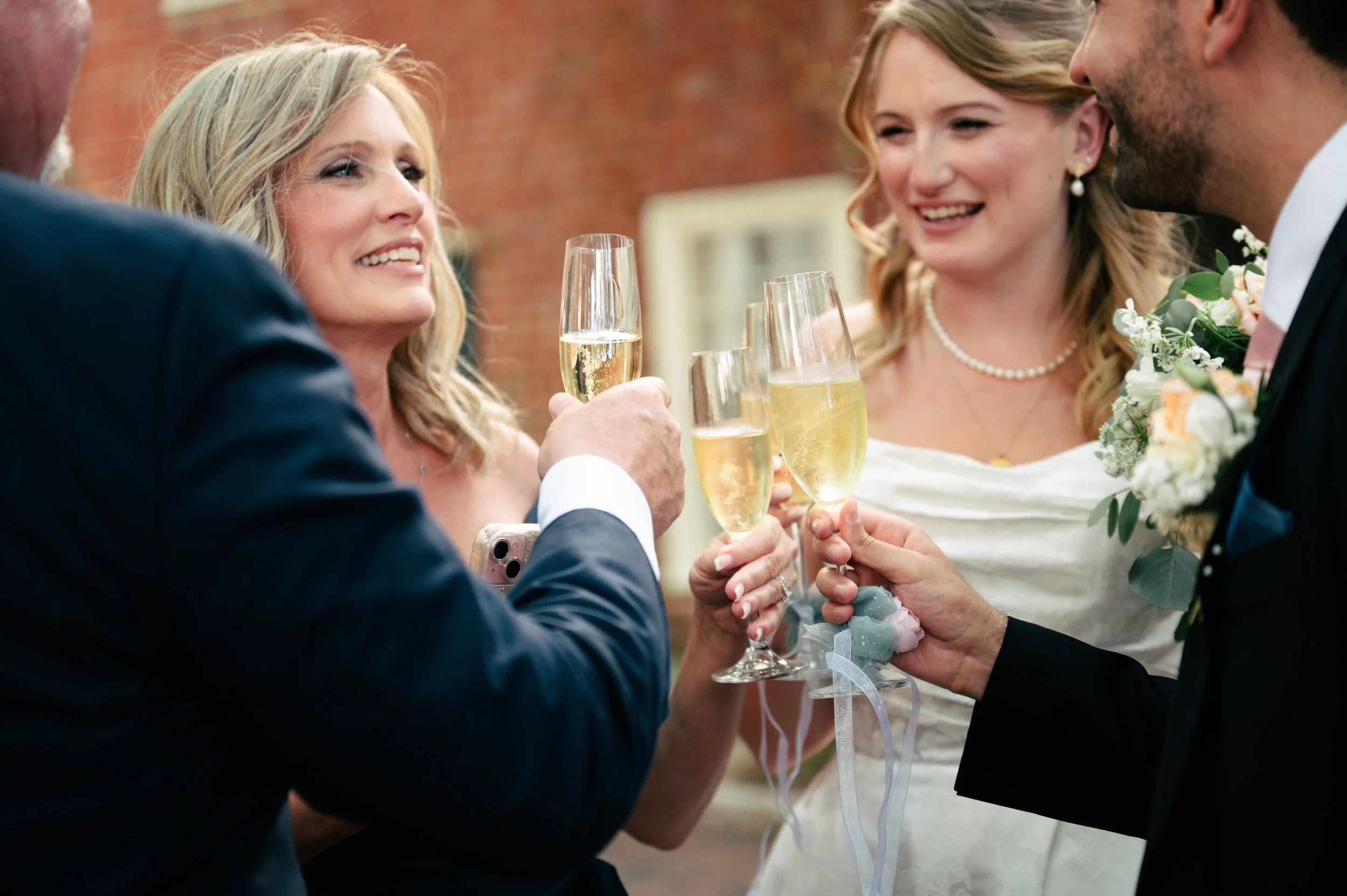 People celebrating at a wedding toasting with champagne glasses.