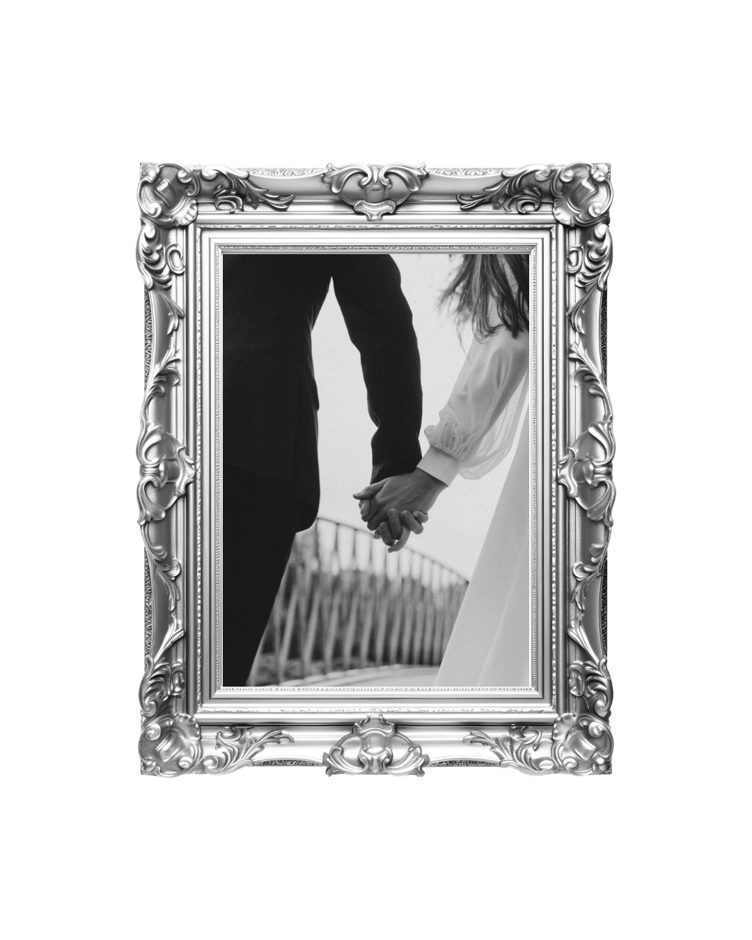 A black and white photo of a couple holding hands, framed in an ornate silver picture frame.