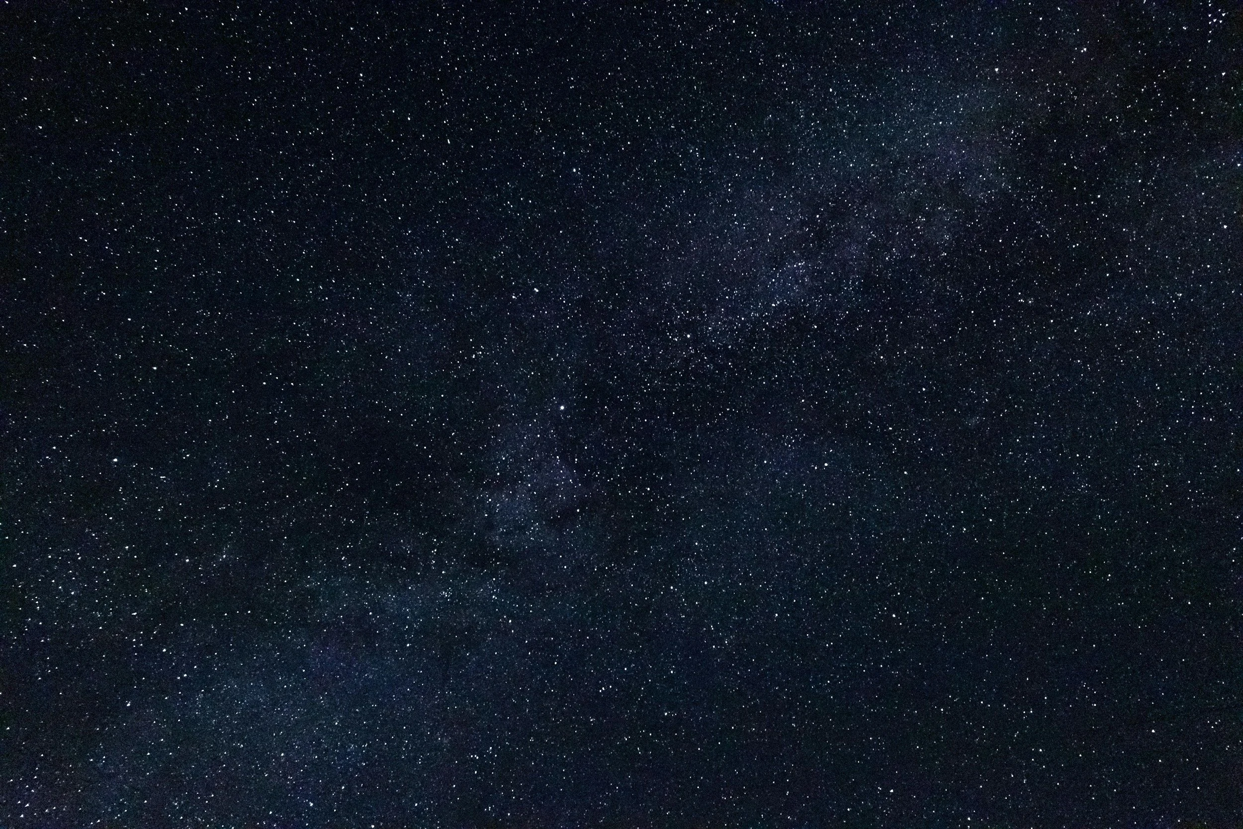 A wide view of a starry night sky with countless stars scattered across the dark space.