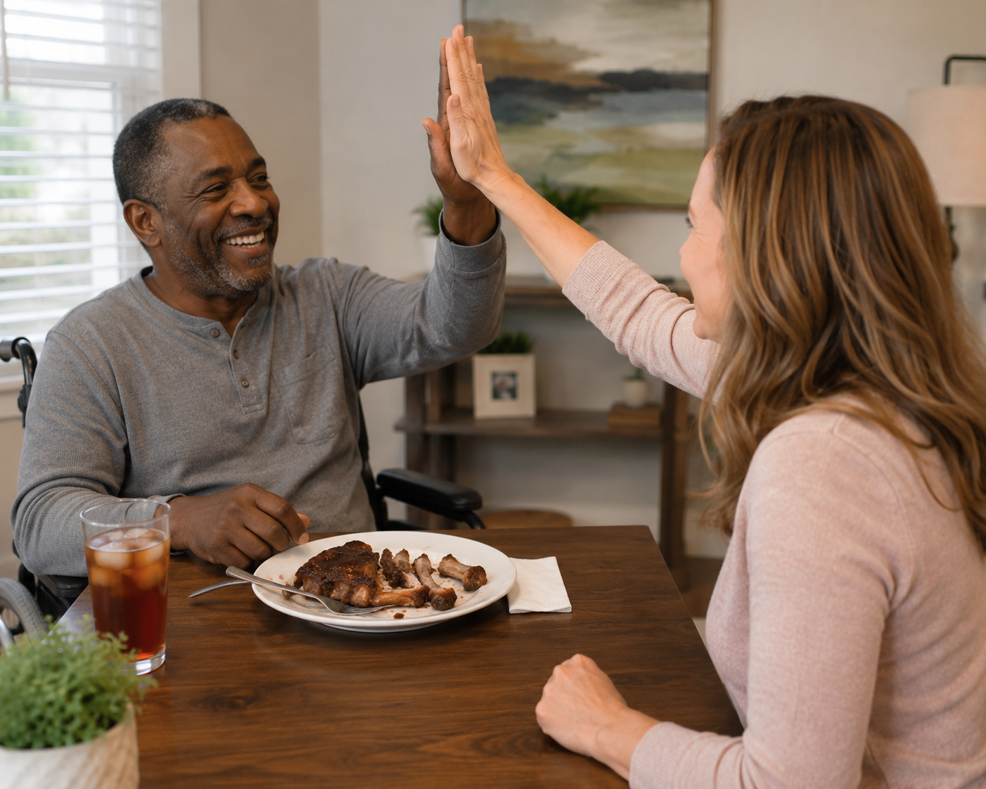 A man receiving swallowing therapy services finishing a meal. He is high-fiving the therapist.