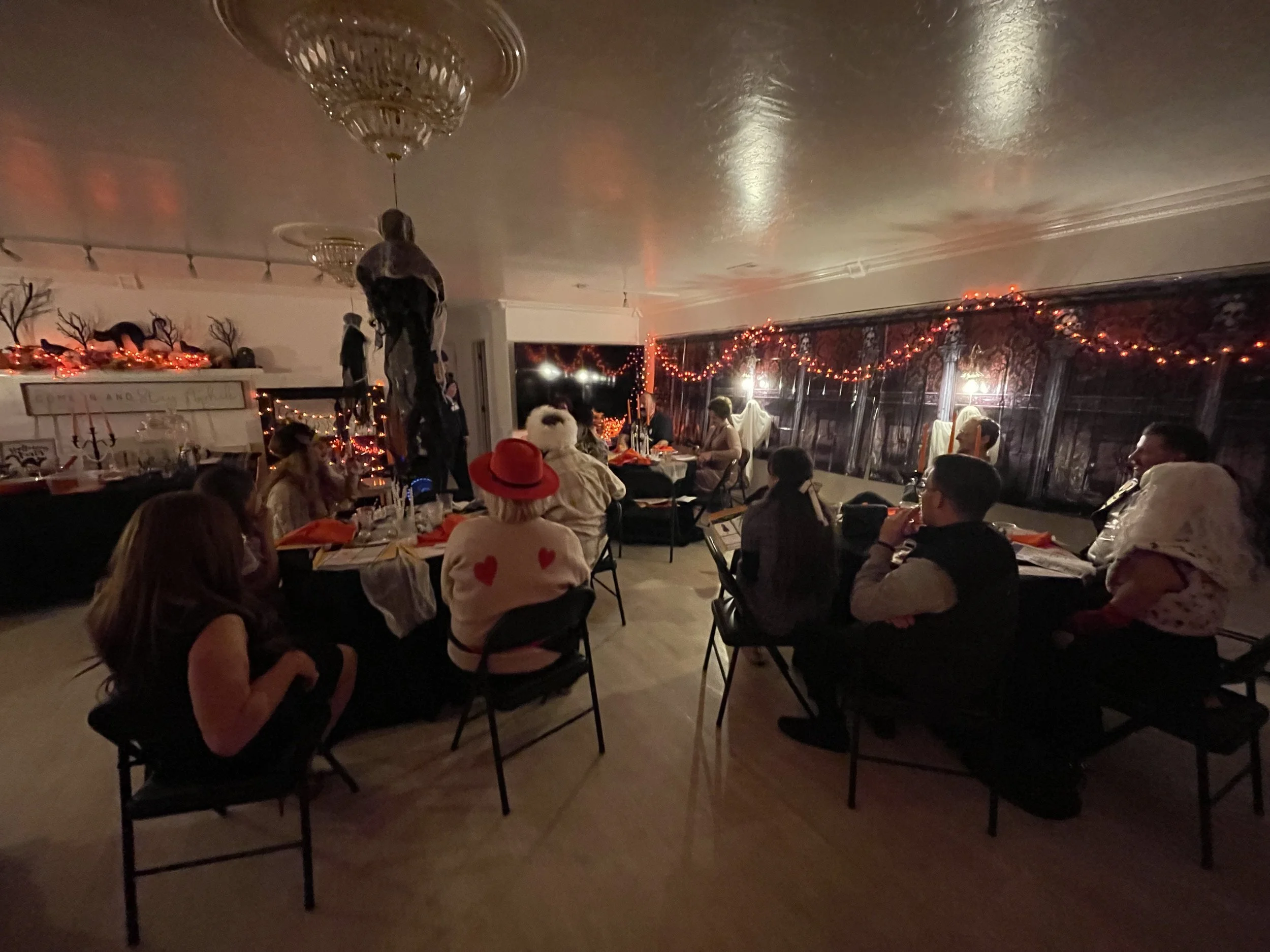 Hounted house themed party with everyone sitting at tables