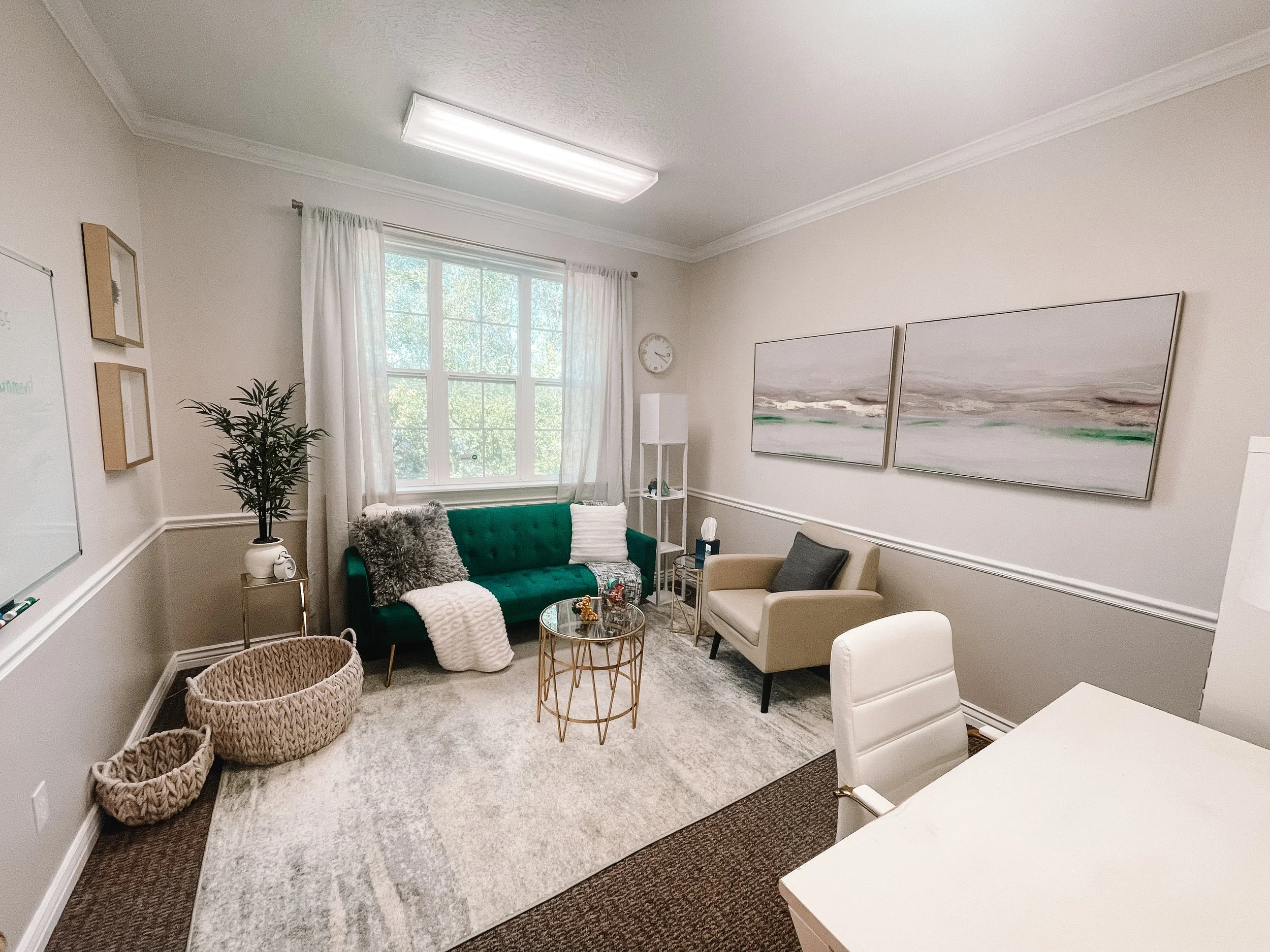 Therapy office with emerald green couch and natural light at Blue Bee Counseling