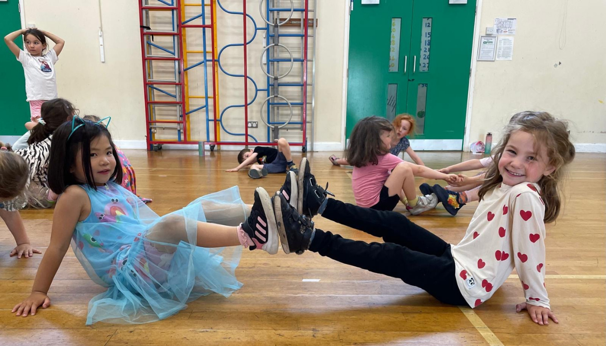 Children taking part in a primary school wellbeing programme in London through creative movement and dance.