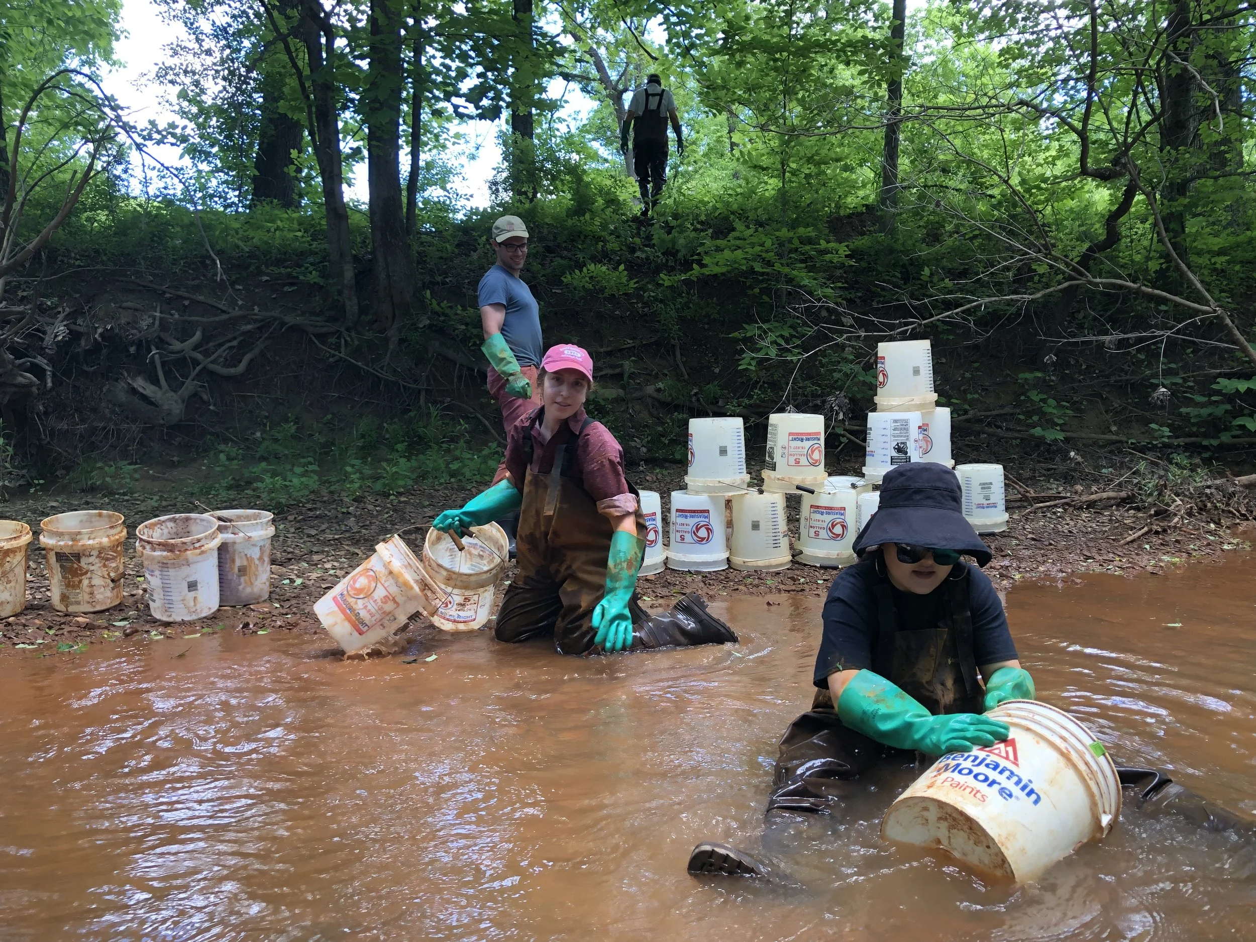 Cleaning buckets in creek.