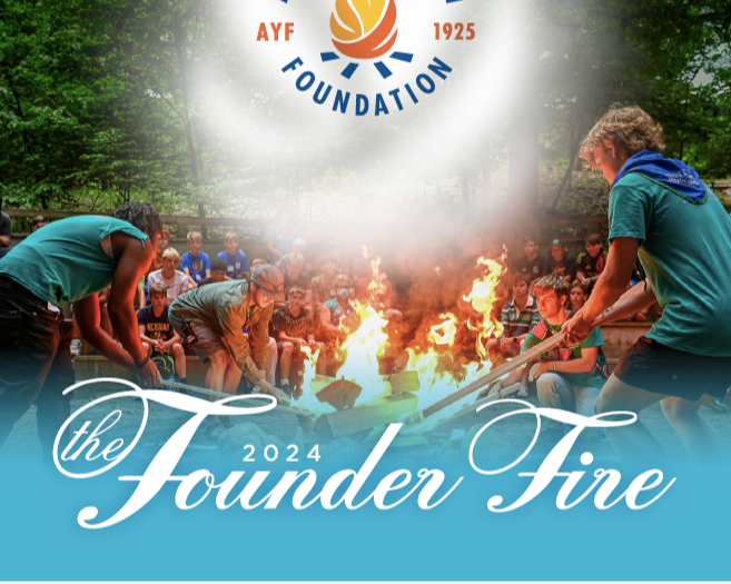 Young people sitting around an outdoor campfire with flames, some tending to the fire, at a campground surrounded by trees, with a crowd watching in the background. The image promotes the 2024 Founder Fire event by the American Youth Foundation.