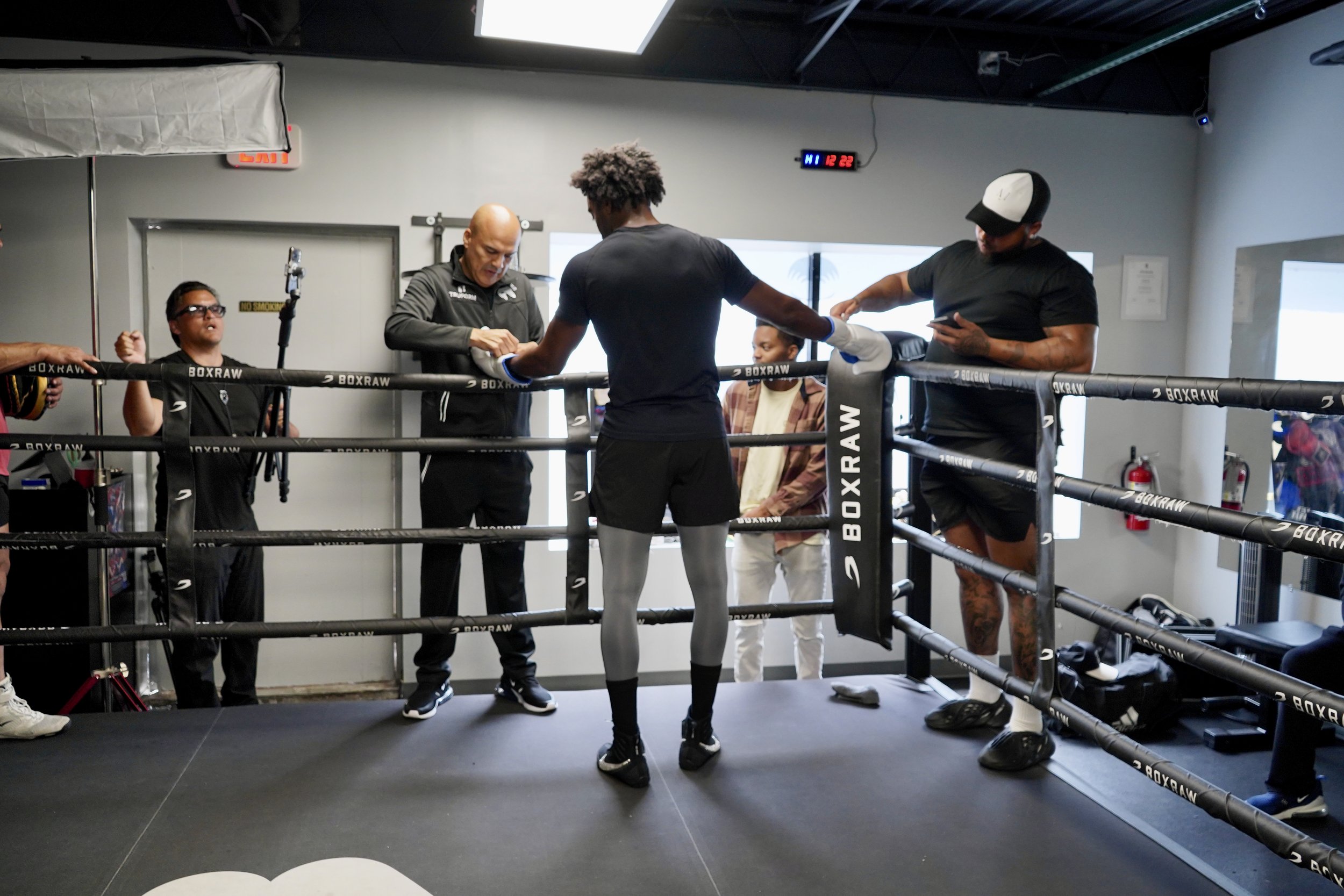 Samuel "S3" Arnold III removes his gloves with manager Gerry Truax following a training session at Strikers Gym in Dallas, Texas.