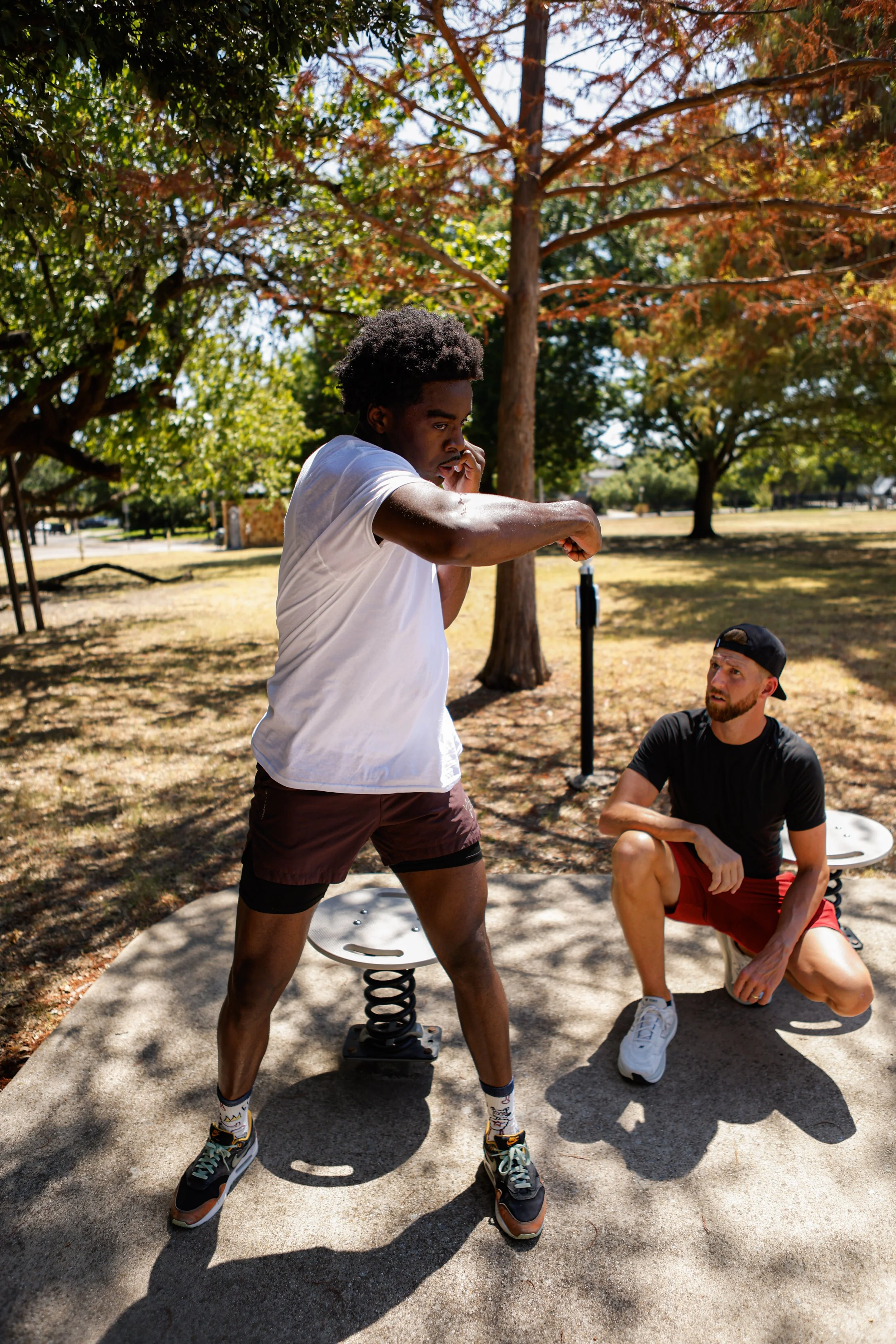 Samuel "S3" Arnold III training on a reflex platform outdoors with Coach Andrew Banner during a fight camp conditioning session.