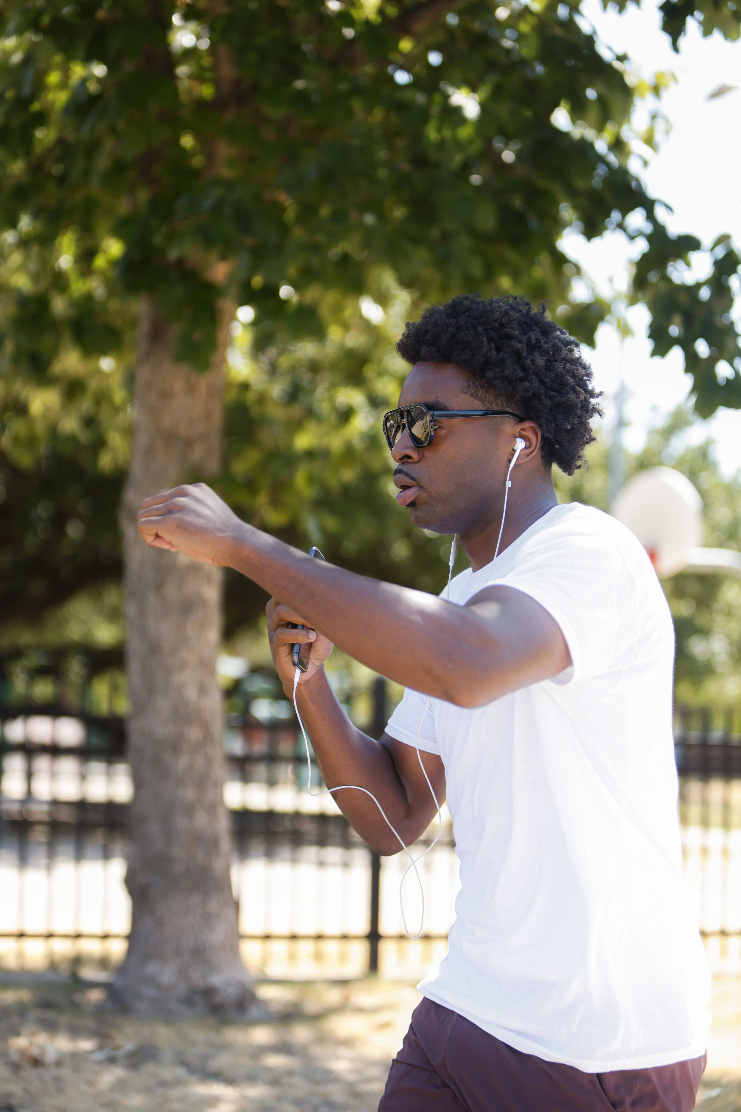 Samuel "S3" Arnold III checking his watch mid-run during outdoor roadwork as part of fight camp training.