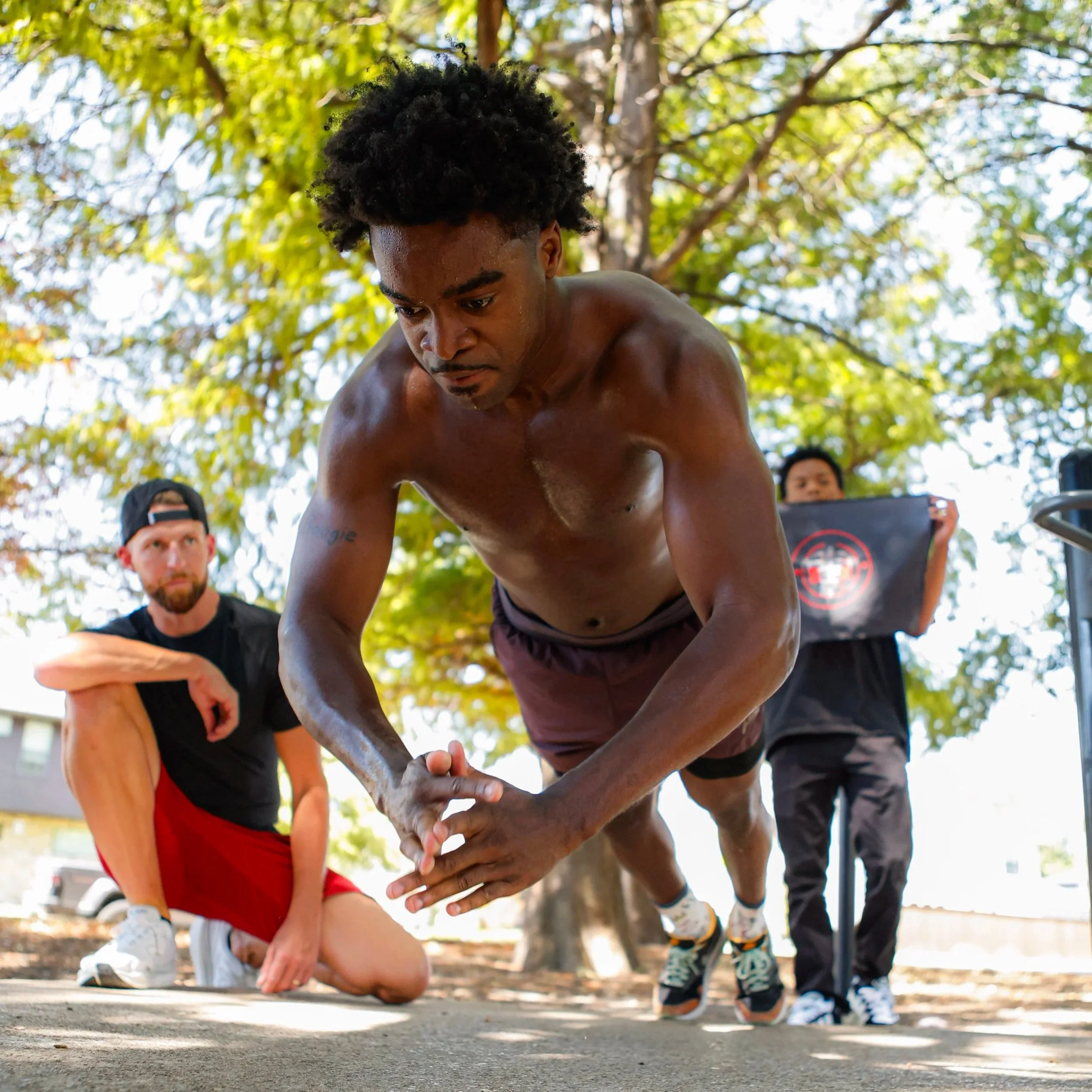 Samuel "S3" Arnold III performing a plyo push-ups with Coach Andrew Banner during an outdoor strength and conditioning session as part of his fight camp training.