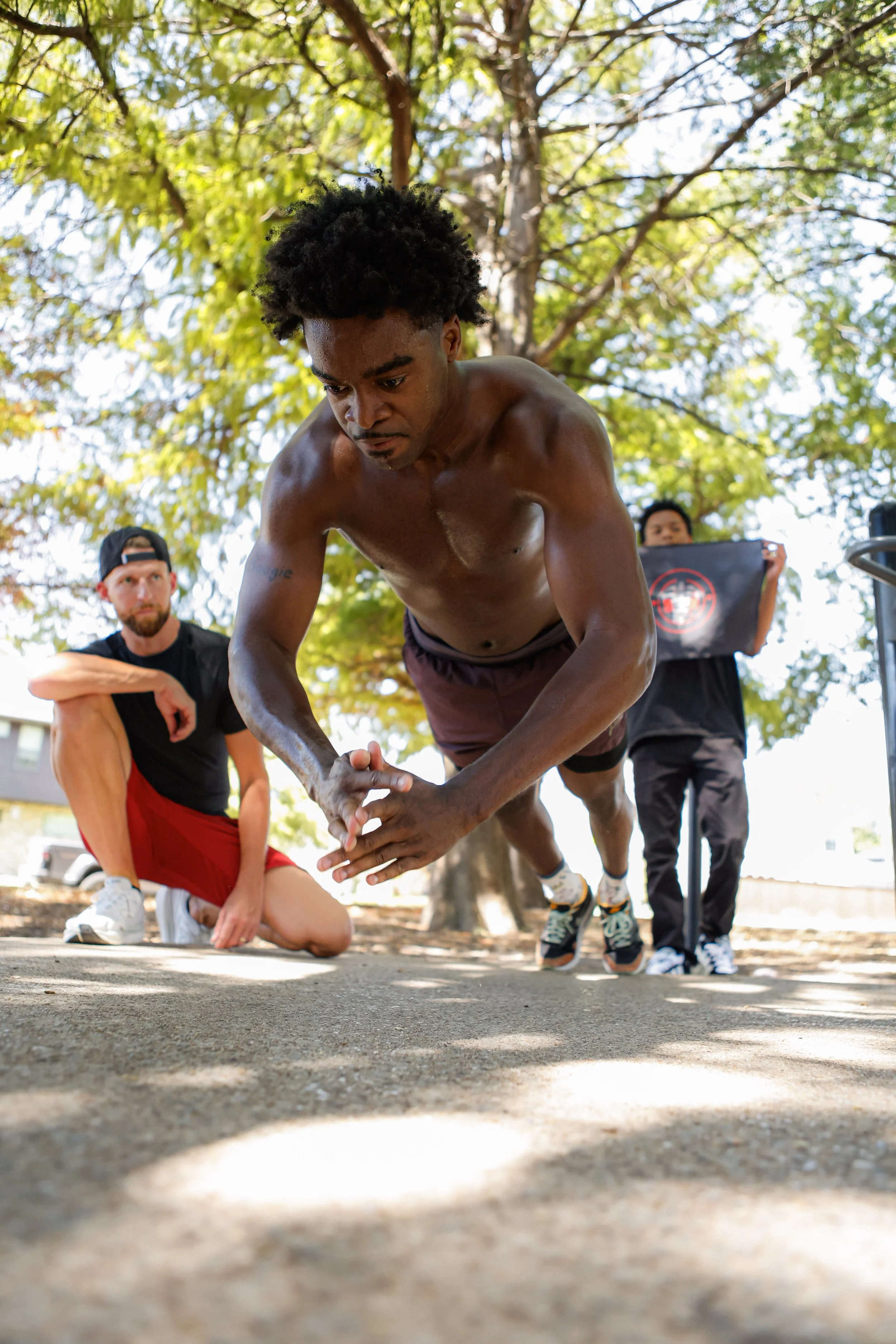 Samuel "S3" Arnold III doing push-ups outdoors with Coach Andrew Banner during a fight camp strength and conditioning session.