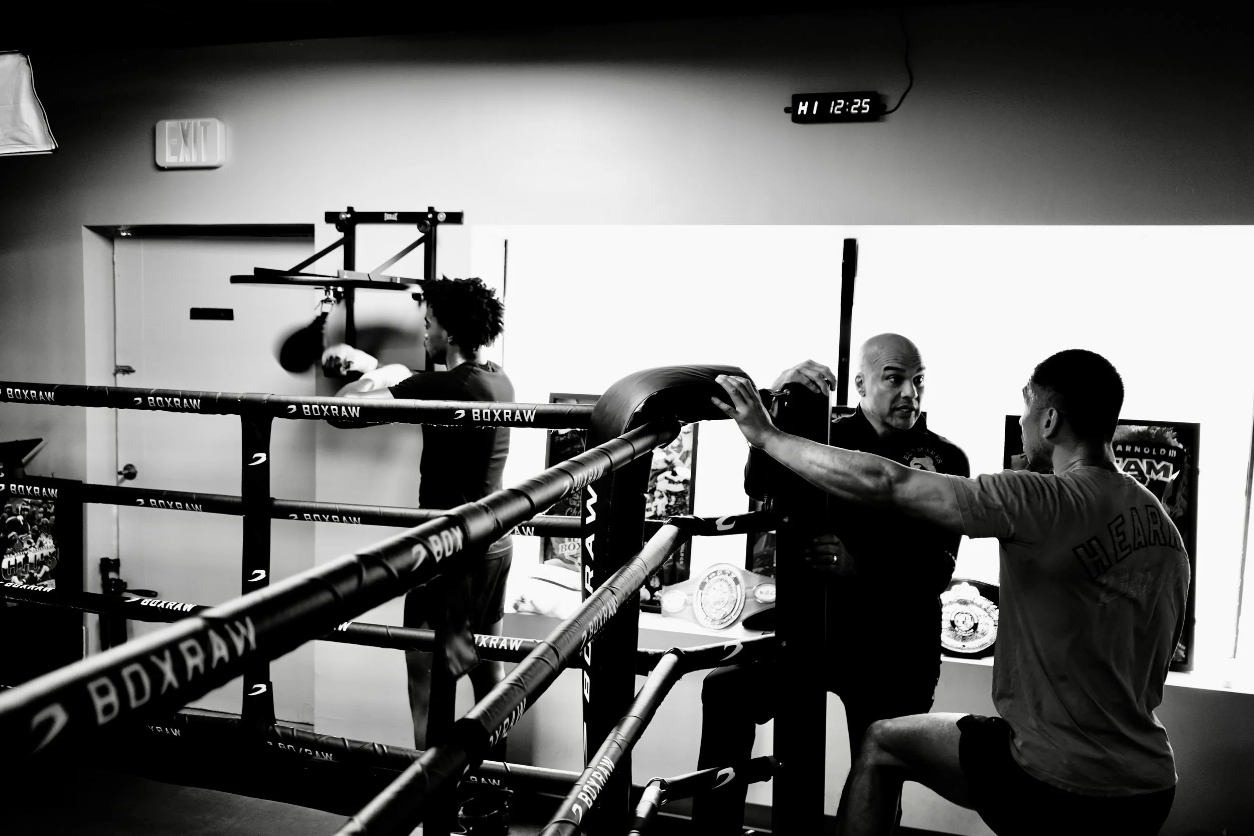 Samuel "S3" Arnold III works the speed bag while manager Gerry Truax and coach John Pruna converse ringside at Strikers Gym in Dallas, Texas.