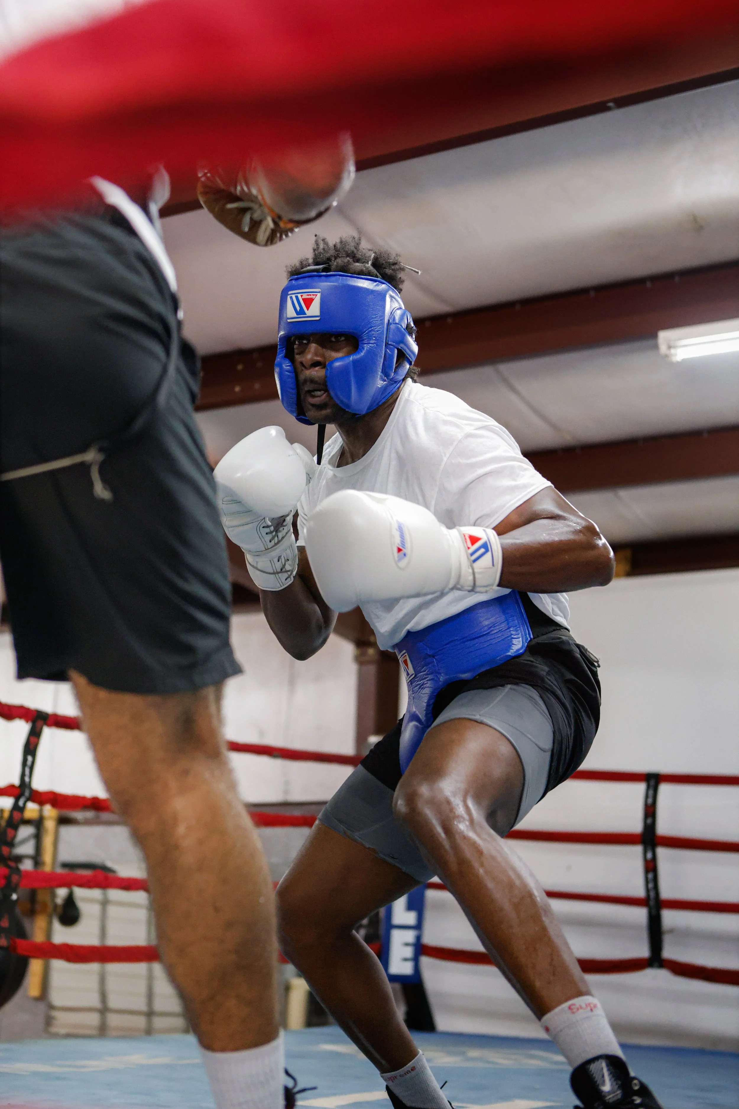 Samuel "S3" Arnold III sparring in headgear against a training partner in the ring during fight camp preparation.