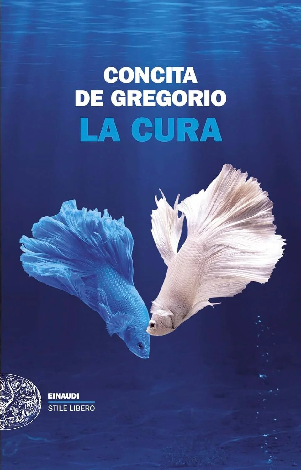 Book cover with a deep blue underwater background, featuring two betta fish facing each other, one blue and one white, with the title 'Concita de Gregorio La Cura' and the publisher 'Einaudi Stile Libero'.